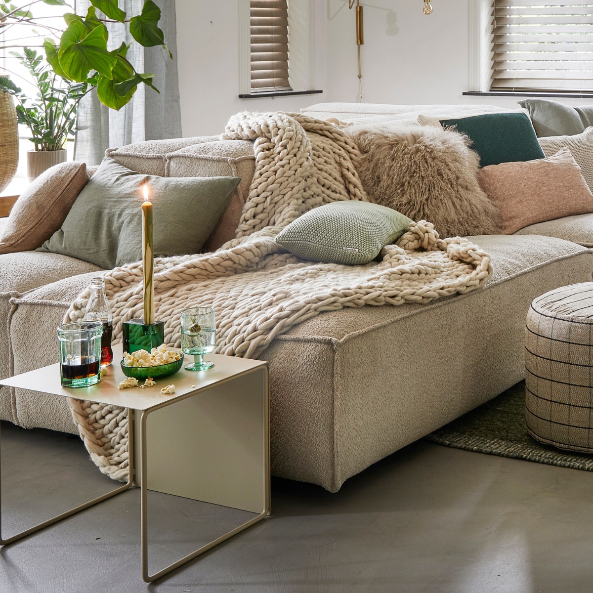 Ecru elementenbank Square van Easy Sofa, per module vanaf € 605,- (hoekbankxxl.nl). Groen geweven vloerkleed Versanti van Linie Design, 240x170 cm € 440,- (vtwonen.nl). Ecru metalen bijzettafel Cluster van Ferm Living, set van 3 € 380,-, grijze geruite poef Grid van Oyoy, 40x38 cm (Øxh) € 104,55, groene kristalglazen kandelaar Parker, 8x3x8 cm € 24,65 (wonenmetlef.nl). Crèmekleurige gebreide plaid, 152x127 cm € 149,- (noirhome.nl). Kussens van links naar rechts: lichtbruin kussen met visgraatmotief Kata van Oyoy, 40x60 cm € 57,80 (wonenmetlef.nl), linnen kussen Olive, 40x60 cm € 59,- (bymolle.com), kussen Nordic Knit van Marc O’Polo, 30x60 cm € 39,99 (vtwonen.nl), schapenvachtkussen, 40x40 cm € 69,- (noirhome.nl), groen gebreid kussen Solid van Malagoon, 50x50 cm € 49,99 (vtwonen.nl), linnen kussen Blush, 35x50 cm € 49,-, gerecycled gebreid denim kussen Sand, 40x60 cm € 79,-, linnen kussen Olive, 60x60 cm € 69,-, linnen kussen Cinnamon, 40x60 cm € 59,- (bymolle.com). Donkergroene merinowollen deken van McNutt, 200x145 cm € 100,-, groen glas van Serax, medium € 9,50, groene glazen popcornschaaltjes Emeralds, 12,5 cm (Ø), per stuk € 12,10, groen aardewerken chipsschaaltje Miscellaneous € 7,- (vanmanenaantafel.nl). Gerecycled wijnglas Oli van Ferm Living € 25,-, gerecyclede glazen karaf Oli Jug van Ferm Living € 39,-, groene kaars Dryp van Ferm Living, per 2 € 11,-, metalen plantenbak op poten Two Tier van Ferm Living, 25x75x80 cm € 299,-, fotolijsten aan rechter wand, vanaf € 35,- (byjensen.nl). Plant Philodendron, groot € 149,95, bamboe mand € 200,-, op side table plant Philodendron € 22,50, groene metalen pot € 35,-, plant rechts Monstera € 28,95, plant voor Asparagus € 44,95, bamboe mand € 89,- (stadstuindebloemenpoort.nl). Messing wandlamp Swing van House Doctor, 65x35 cm € 199,-, mosgroene keramieken vaas Eminent Circles, medium € 49,99, keramieken tafellamp Stoneware met lampenkap van HKliving € 209,-(vtwonen.nl). Terracotta bloempot Rosa, 12 cm (Ø ) € 9,50 (bymolle.com). Lichtbruin aardewerken suikerschaaltje Hagi van Oyoy (wonenmetlef.nl). Overig privébezit. vtwonen 02-2023 | styling Femke Pastijn | fotografie Peggy Janssen