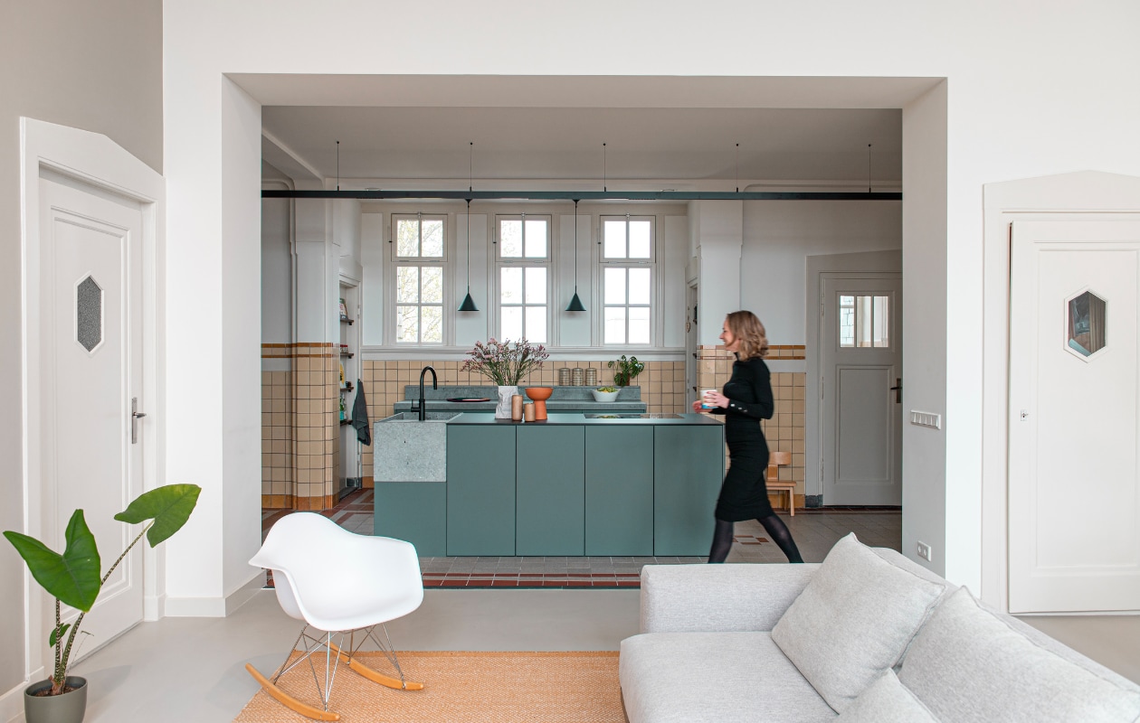 Keuken Houtmerk, kraan Quooker, hanglampen HKliving, omkeerbare fruitschaal/vaas Flip van Carissa Ten Tije. Waxinelichthouders kringloopwinkel, kreukvaas Serax, schommelstoel Eames Rar van Vitra, bank en vloerkleed Muuto, plantenpot Elho. Overig onbekend. vtwonen special binnenkijken 11-2023 | productie De Binnenkijkers | styling Jeske Weel | fotografie Caroline Coehorst