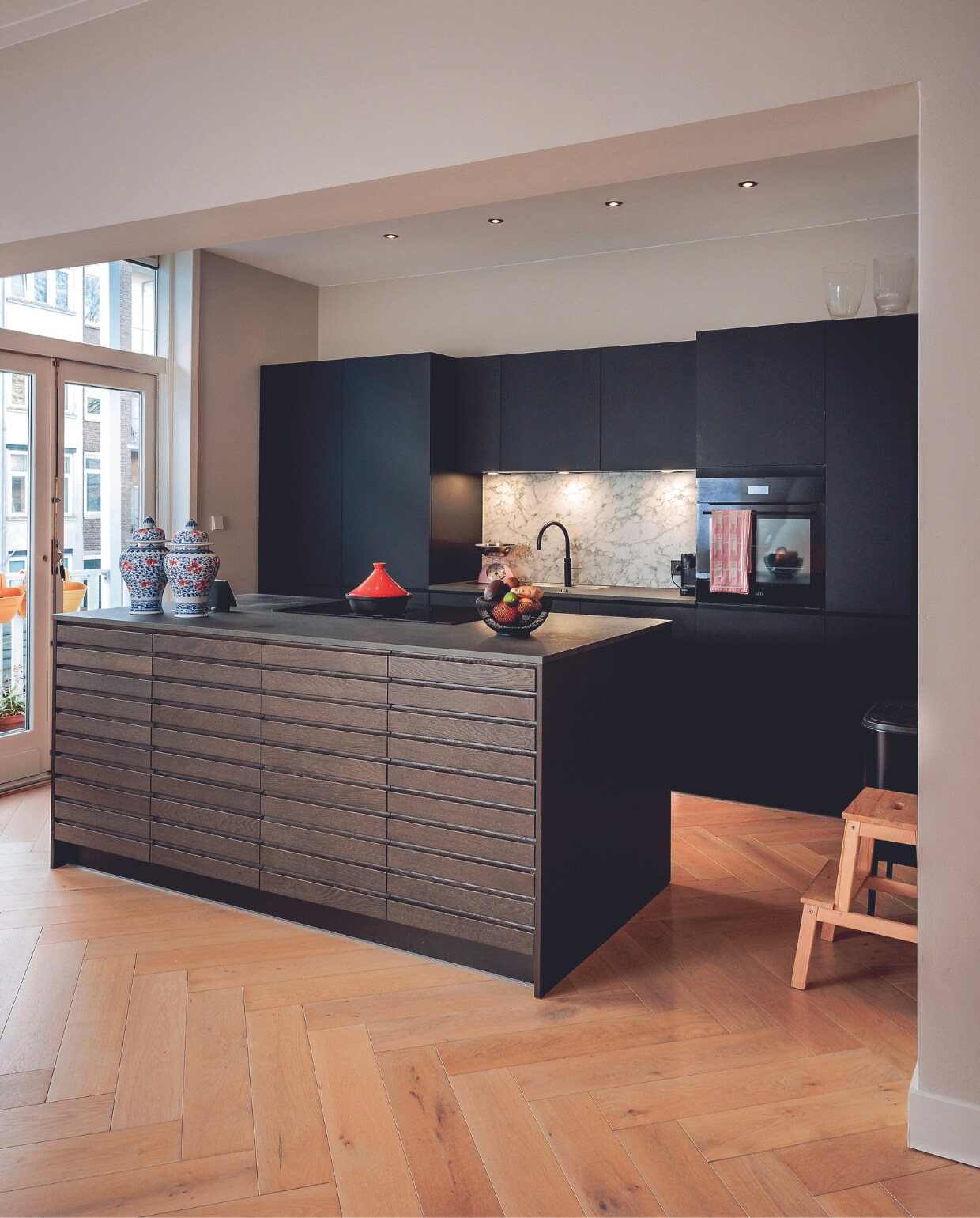 De lange eettafel moest plaatsmaken voor dit kookeiland van donker eikenhout. Dat was even slikken, maar is veel praktischer. Keuken Kvik. vtwonen 03-2024 | fotografie Ernie Enkelaar