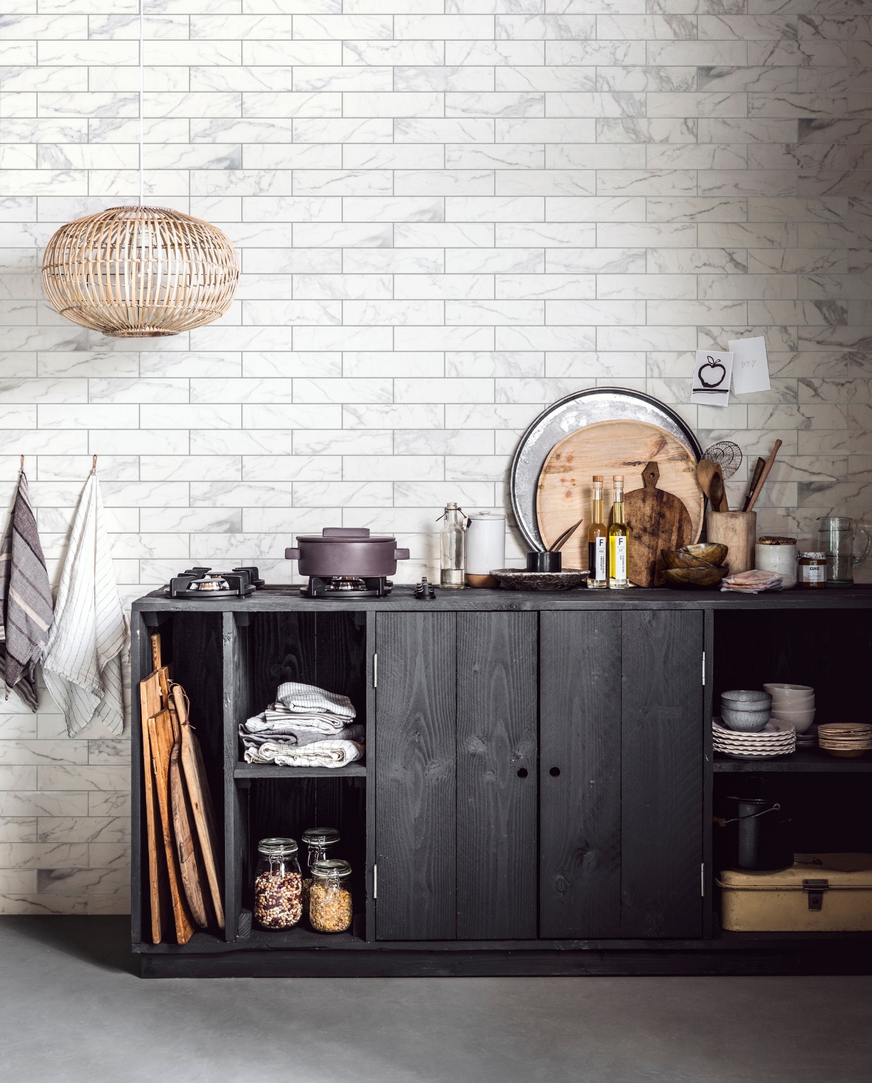 Tegel Marble White Statuario, 7x28 cm per m² € 47,95M.m.v. Létoile (handdoek clip met leren bandje, wit linnen theedoek, stapel linnengoed in kasr, lepels van hoorn, schaaltjes van hoorn), Maisonnl (grijs gestreepte theedoek), Store Without a Home (rotan hanglamp), Pitt Cooking (gaspitten die je rechtstreeks op je aanrecht kunt plaatsen), vtwonen.nl (gietijzeren pan, houten xl bord), De Weldaad (fles, rond metalen dienblad, oude snijplank op aanrecht), Loods 5 (zwart-wit gestreepte tafellopers opgevouwen in de kast, grijze pot met kurken onderkant, houten opberger voor pollepels, glazen kan, borden met geschulpte rand, grijze borden, witte kommen, bamboe schaaltjes), Brechtje Olsthoorn (diep stenen bord), &amp;Klevering (olijfolies, pot custard), Raw Materials (grijze kommen), Burbri Antiek (broodtrommel, zwarte emaillen pan met deksel). vtwonen 10-2017 | styling Danielle Verheul | fotografie Sjoerd Eickmans