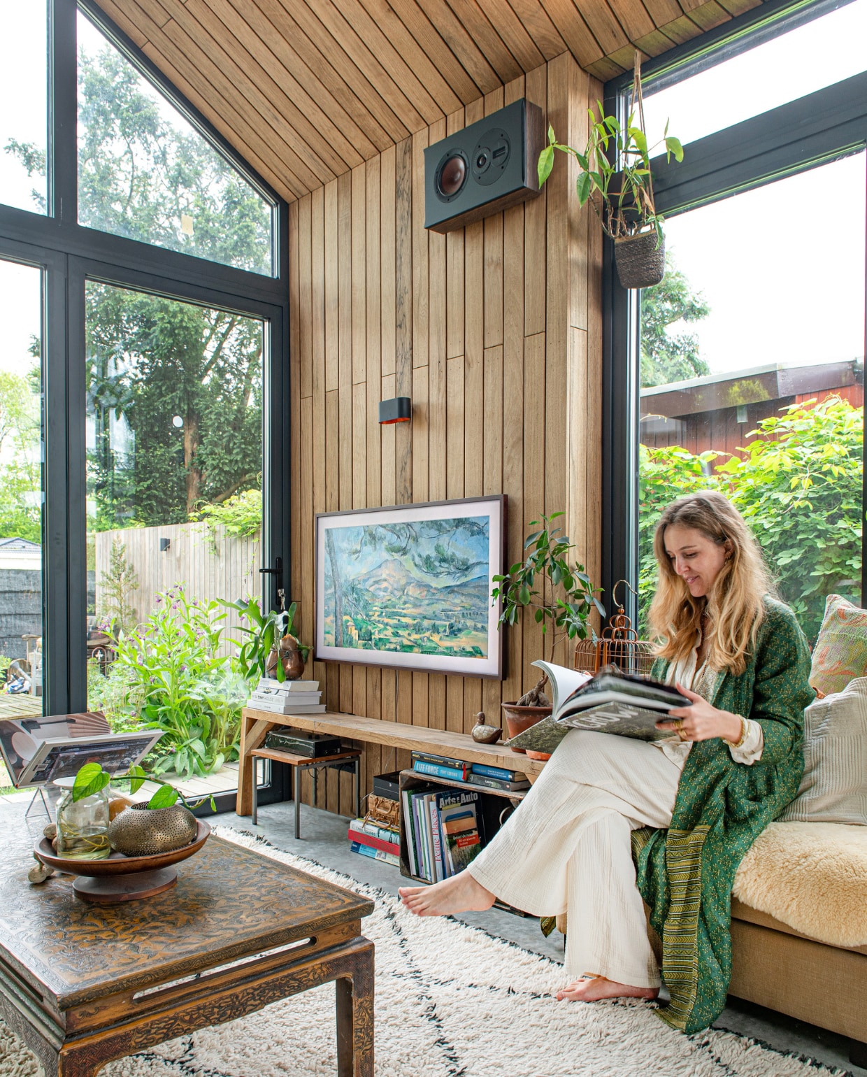 Houten bank zelfgemaakt, televisie The Frame van Samsung. Vloerkleed, hocker en tafel tweedehands. Vogelkooi meegenomen uit China, wandlamp veilingsite, speaker Bluesound. Overig onbekend. vtwonen DIY special 08 | fotografie Caroline Coehorst