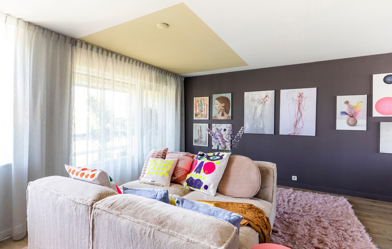 Flexa Creations muurverf achter de kunst Dark Tulip, op het plafond Misted Grey, kleurvlak op het plafond Wild Wonder (flexa.nl). Gordijnen van vtwonen, per meter € 30,99 (karwei.nl). Bank, per element € 599,-, vloerkleed € 1090,-, rechthoekig kussen met roze print van Malagoon € 49,-, vierkant kussen met roze print van Malagoon € 39,95, plaids van Malagoon, per stuk € 39,95 (eijerkamp.nl). Blauwe kussens van Hay, per stuk € 85,-, rond fluwelen kussen van HKliving € 129,90, roze bijzettafel van Pols Potten € 325,-, bijzettafel achter de bank van Hay € 239,-, glazen vaas op de bijzettafel van House Doctor € 20,50, (vtwonen.nl). Gekleurd kussen Love € 49,-, gekleurde kussens gezichten, per stuk € 65,-, gekleurd kussen met gele stippen vanaf € 45,- (diedshop.com). Kunstwerk Collageprint met foto van een cactus van Renske € 62,-, kunstwerk Ancient Wisdom van Renske € 83,-, kunstwerk Collageprint met foto van een cactus van Renske € 62,-, kunstwerk patroon met grafische vormen van Renske € 83,-, kunstwerk Lovable van Kim Rijntjes € 183,- (werkaandemuur.nl). Overig privébezit. Weer verliefd op je huis aflevering 3 seizoen 17 | styling Marianne Luning | fotografie Margriet Hoekstra