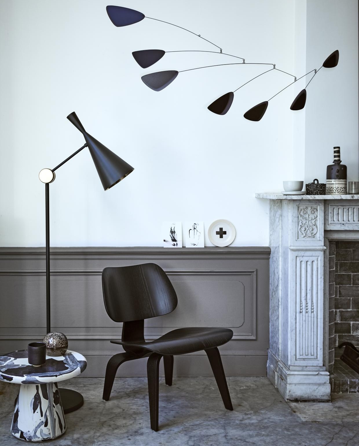 Mobile van Volta € 279,-, staande lamp Beat van Tom Dixon, hoogte 165 cm € 1025,-, zwarte fauteuil Plywood Group LCW van Eames € 1390,- (Homestede). Bordje met kruis van Marga Janssen € 25,50 (Pols Potten). Zwart-witte vaas € 169,- (MaisonNL). Kaarten van Petra Lunenburg € 10,-, kom € 16,-, klein schaaltje € 8,- (Sukha Amsterdam). Zwart bakje met stippen en deksel van Ferm Living € 34,-, bruin bolvormig bakje € 22,50, zwart potje met deksel € 39,95 (Six and Sons). Bijzettafel Melting Pot van Dirk Vander Kooij, 40x30 cm € 505,-(The Frozen Fountain). vtwonen 02-2018 | fotorafie Jeroen van der Spek | styling Cleo Scheulderman