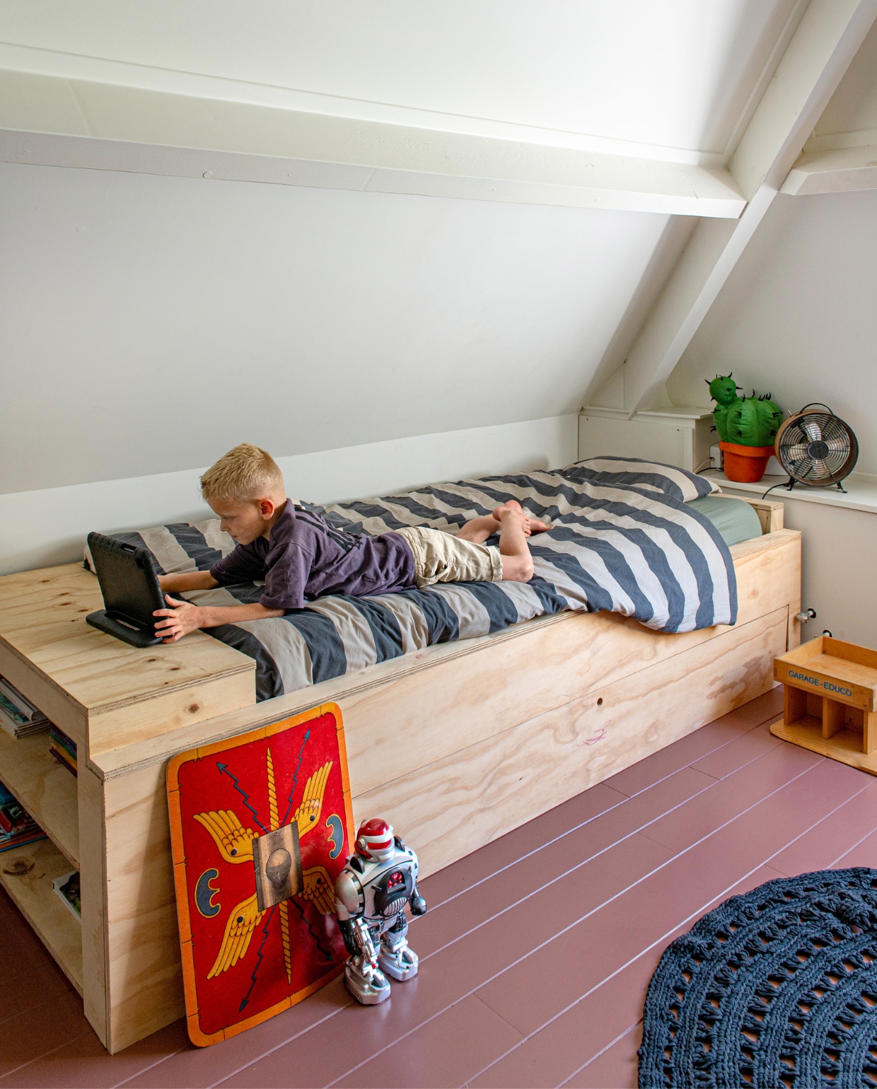 Bed zelfgemaakt van underlayment platen met een oud bed als basis, beddengoed H&amp;M. Schild gekregen, robot familiestuk, garage @dekringloopzusjes, cactus Ikea vtwonen special 131-2024 | productie De Binnenkijkers | styling Jeske Weel | fotografie Caroline Coehorst