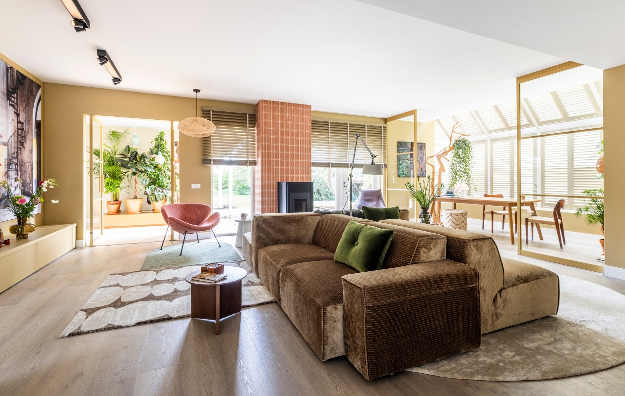 Muurverf Sure Thing van Flexa Flexa. Muurverf (in de nis) Easy Peasy van Flexa Flexa. Houten tv-dressoir op maat gemaakt door Michiel Remmers, gelakt in de kleur Sure Thing van Flexa Remmers Design. Houten klepbank en planken op maat gemaakt door Michiel Remmers, gelakt in de kleur Easy Peasy van Flexa Remmers Design. Houten jaloezieën van Jasno in de kleur Grey Oil, elektrisch bedienbaar Jasno Shutters. Dubbele taatsdeuren en taatsdeur naar de keuken in kleur Goud van GewoonGers GewoonGers. Pvc-vloer Kratos van Bodiax Aanhuis.nl. vtwonen tegels by Douglas & Jones: Chop Mattone 3D Decor, 5x15 cm Douglas & Jones. Kunstwerk Portret van Marie Henneberg van Gustav Klimt uit de Oude Meesters Collectie, aluminum dibond mat, 90x90 cm Werk aan de Muur. Kunstwerk Verlaten metalen trap van Roman Robroek, art frame met zwart frame, 130x195 cm Werk aan de Muur. Elementenbank Noxx, stof Monty, 1,5-zits 100x71x101 cm, 2,5 zits 189x71x101 cm en hocker 70x42x101 cm Eijerkamp. Roze fauteuil Orange Slice, 84x70x80 cm Eijerkamp. Leren fauteuil Beal, kleur Chocolat met een geborsteld rvs onderstel Eijerkamp. Leren hocker Beal, kleur Chocolat met een geborsteld rvs onderstel Eijerkamp. Grijsbruin houten dressoir Basu van Basic Label, 200x86x46 cm (lxhxd) Basic Label. Vloerkleed Stones Balanced Beige Square 2 van Brinker Carpets, 155x150 cm Brinker Carpets. Vloerkleed Arrow Balanced Beige Square 2 van Brinker Carpets Brinker Carpets. Vloerkleed Swirl Nature Green Oval 5 van Brinker Carpets, 150x120 cm Brinker Carpets. Vloerkleed Concrete Balanced Beige Oval 1, 300x190 cm Brinker Carpets. Bruine salontafel Slit van Hay, 35,5x45 cm (hxØ) vtwonen. Roze bijzettafel Amalie van By Fonq, 45x45,5 cm (hxØ) vtwonen. Grijze bijzettafel Button van vtwonen, 45 cm (h) vtwonen. Plafondlampen Centris 4-lichts van Philips Hue, kleur zwart, materiaal metaal, 99x8,5x12,8 cm (lxbxh) Philips Hue. Vloerlamp Bolt 2-arm up Eijerkamp. Hanglamp Maze van Raw Materials, 31x60 x57 cm (hxbxd) vtwonen. Groen velours kussen Dot van Hay, 45x60 cm (hxb) vtwonen. Groene vaas Steps L van Polspotten, 50x35 cm (hxØ) vtwonen. Beige keramieken kandelaar Compolt van Hay, 14,5x13,5 cm Basic Label. Groene glazen vaas (op het tv-meubel) van vtwonen vtwonen. Haard, tafellamp (op het dressoir), tv, plaid, boeken en overige accessoires privébezit.