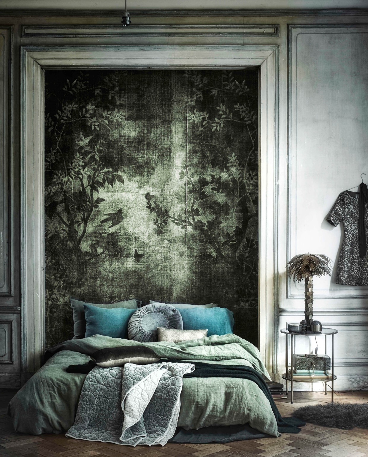 Behang op maat gemaakt WDMN1501 per m² € 95,- (Wall &amp; Decó). Fluwelen quilt € 99,95, kussen met pailletten € 37,50 (Stapelgoed). Rond fluwelen kussen € 53,50, ronde bijzettafel € 250,- (Madam Stoltz). Goudkleurige palmlamp € 350,- (HK Living). Groen oud geldkistje € 35,- (Burbri). Groene wollen deken € 495,- (Meker Wonen). Groen linnen dekbedovertrek 220x240 cm € 295,-, linnen kussenslopen 50x70cm € 35,- (Couleur Locale). Groene marmeren bal € 40,- (Six and Sons). Goudkleurig doosje € 42,50 (Maison NL). Schapenvacht € 185,-(Nordal). Jurk (Six and Sons). vtwonen 12-2016 | styling Cleo Scheulderman | fotografie Jeroen van der Spek