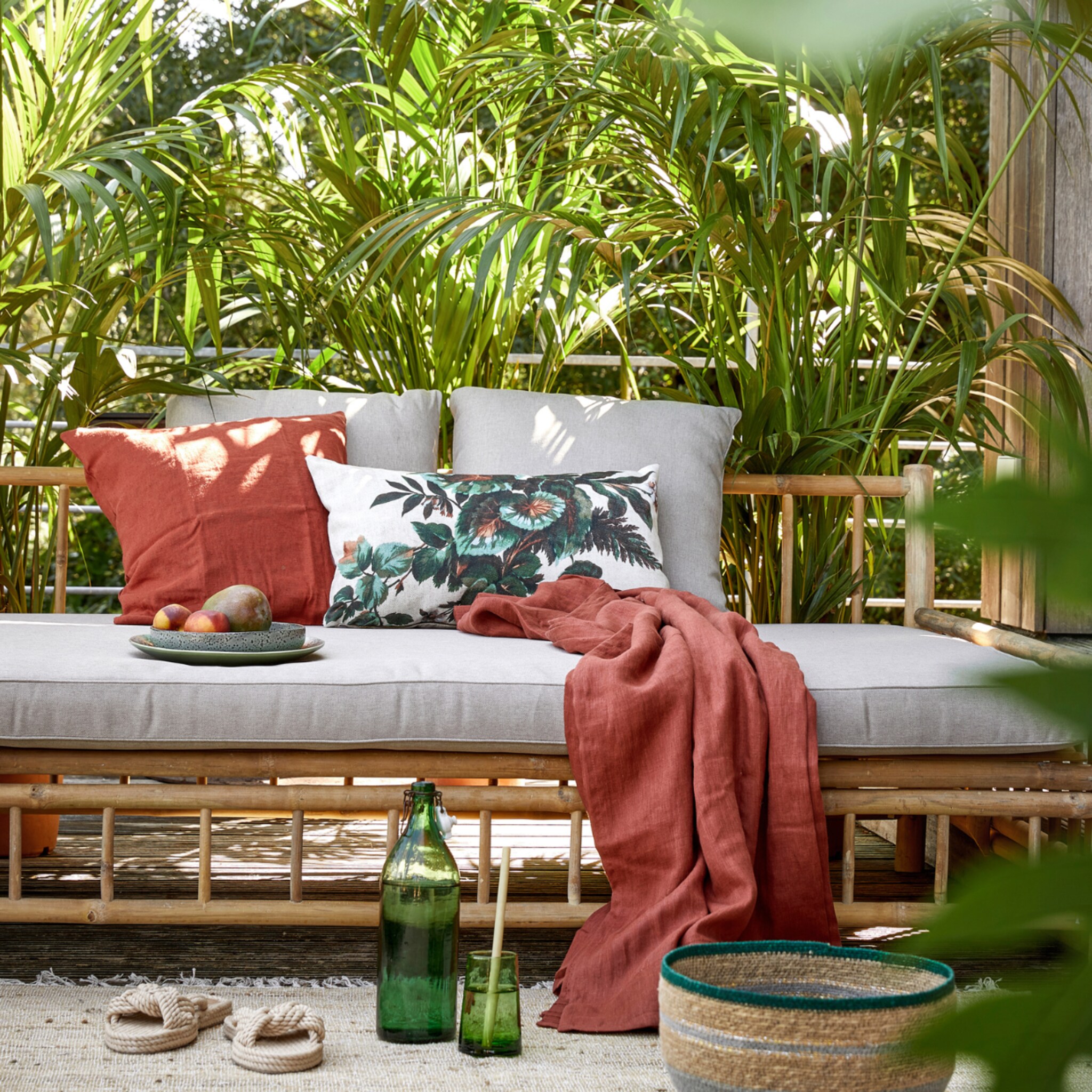 Tuinmeubels met rode sprei en kussens