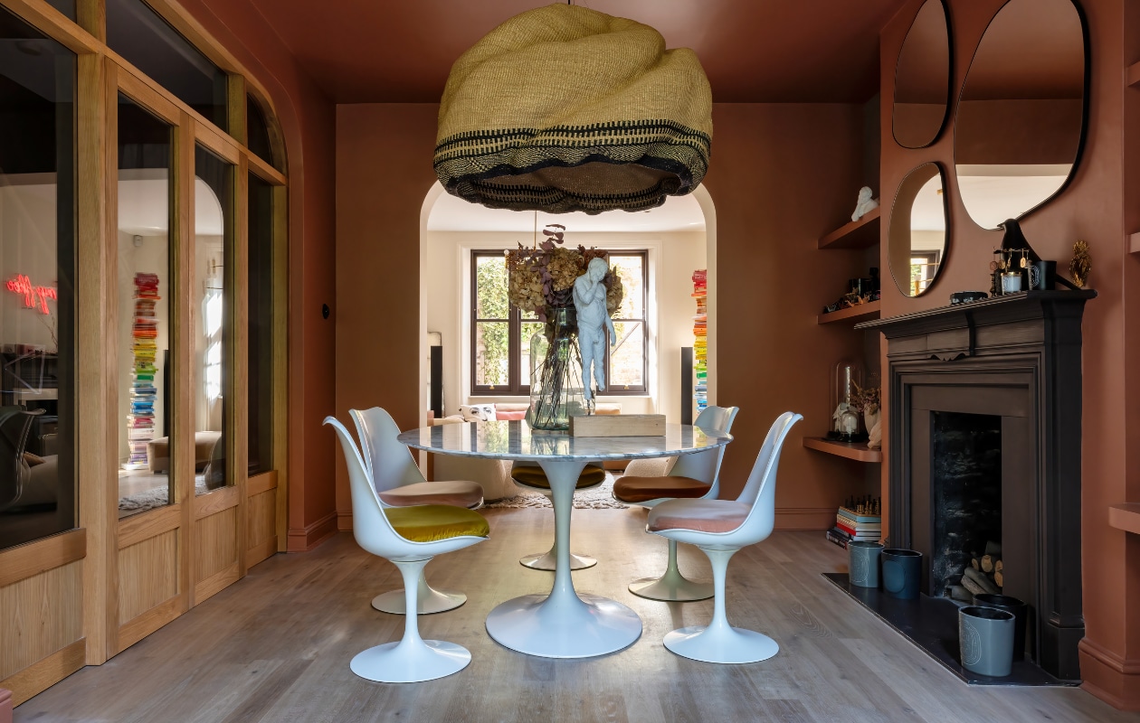 Muurverf Fox Red van Farrow &amp; Ball, eettafel en stoelen Eero Saarinen voor Knoll, wit beeld gemaakt door Karine, hanglamp Bolgatanga van Pet Lamp, spiegels La Redoute. Overig onbekend. vtwonen special 131-2024 | productie Photofoyer | fotografie Benedicte Drummond | styling Fiona Evans