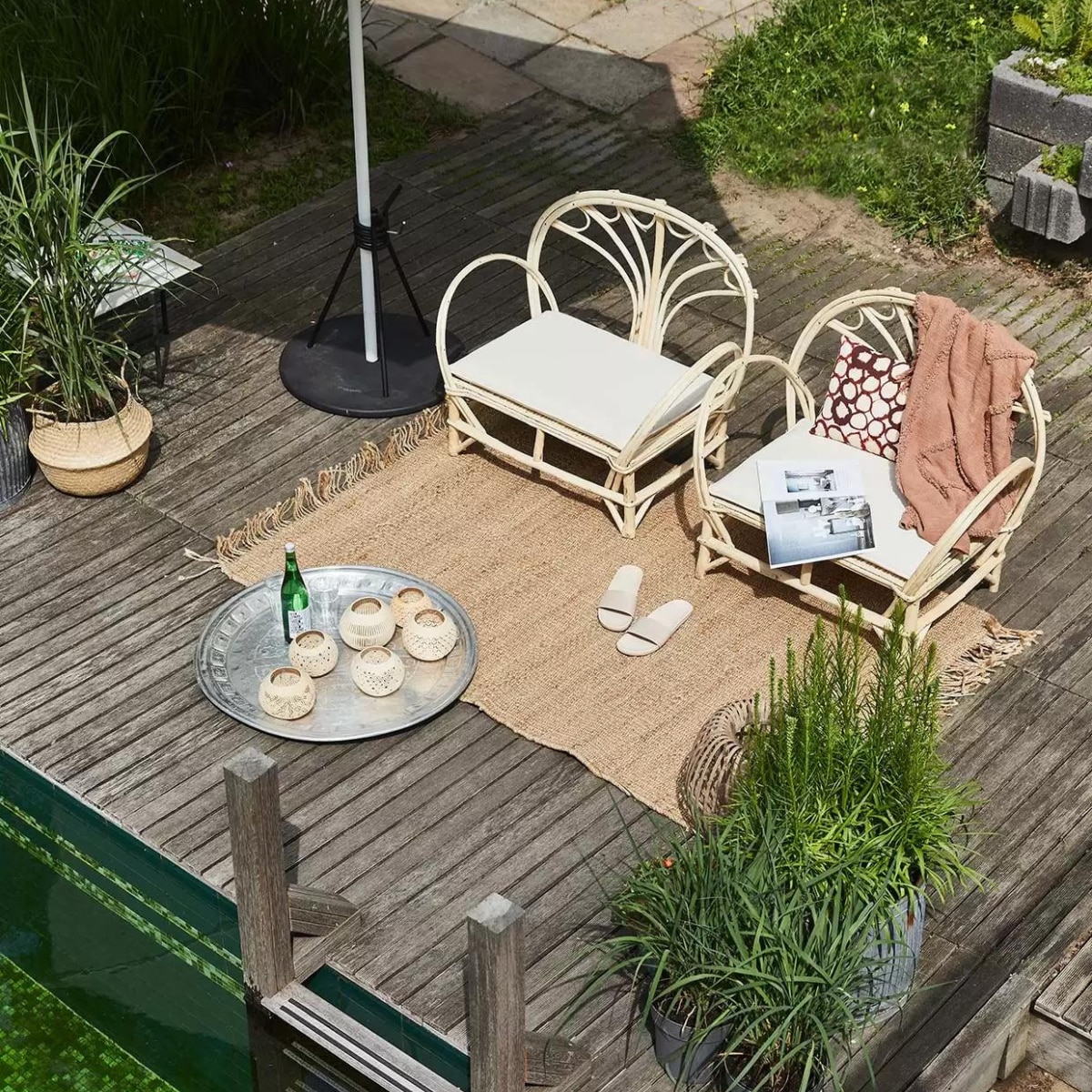 Handgemaakte loungestoelen uit Essaouira, Marokko, en natuurlijk volop zon: dat zijn de ingrediënten voor een vakantie in tropische sferen. Geef er een eigen draai aan met aluminium dienblad, vintage, 75 tot 110 cm (Ø) (householdhardware.nl). Coconut windlicht uit Bali, 13 cm (Ø), slippers soortgelijk bij Sukha (sukha.nl). Plaid 130×170 cm, vloerkleed 12×180 cm (hkliving.nl). Mand Flädis (ikea.com). Aluminium parasol, 200×200 cm, parasolvoet (extravert.nl). Overig privébezit. vtwonen special tuin 03 2021 | styling Fietje Bruijn | fotografie Alexander van Berge
