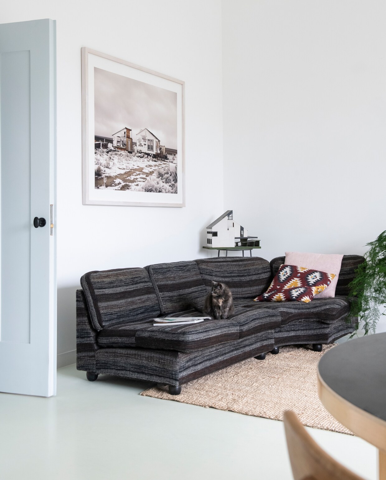 'Deze foto van Roderik Henderson hing bij mijn ouders thuis. Zij gaven hem mij cadeau toen ik hier ging wonen.’ Jaren 70 Artifort bank gekocht op Catawiki. Roze kussen Linum. Ikat-kussen en vloerkleed Ikea. Hoog stalen tafeltje Wereldwinkel met een maquette van ouderlijk huis. vtwonen special 03-2020  | productie InsideHomePage | styling Kristel de Jong | fotografie Louis Lemaire
