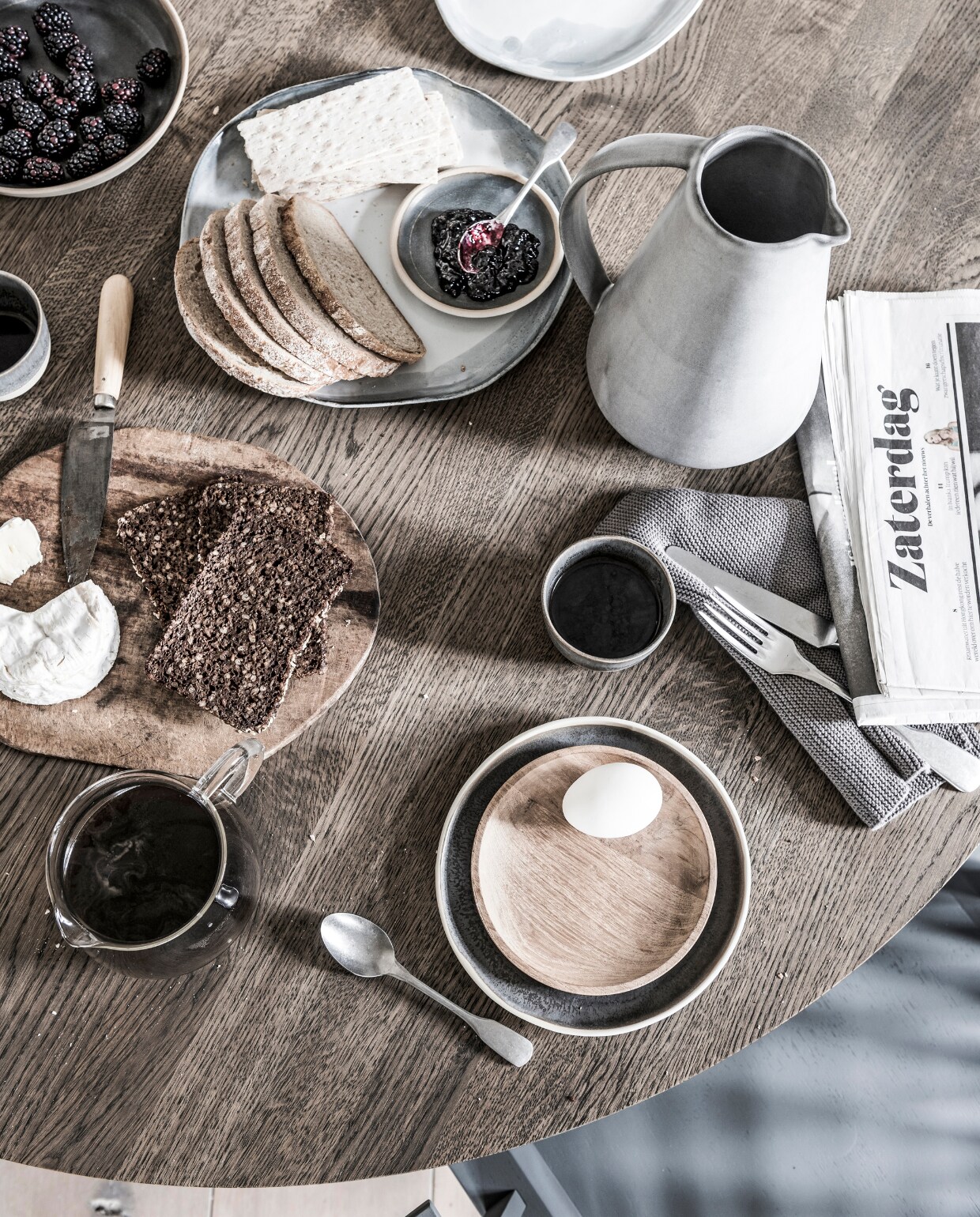 Donkergrijs bord van keramiek met witte rand € 25,-, houten bord € 7,50, donkergrijze mokken van keramiek met witte rand, per stuk € 24,-, donkergrijs bord van keramiek met witte rand € 35,- (Annemieke Boots Ceramics). Lichtgrijs gevlekt bord € 23,52, lichtgrijze kan € 59,51 (Dassie Artisan). Stoffen servet, set van 3 € 14,- (Tine K Home). Glazen koffiepot € 16,- (Six and Sons). Grijze houten spijlenstoel € 687,- (Carpentier Wonen). Overig privébezit. vtwonen 03-2018 | styling Danielle Verheul | fotografie Sjoerd Eickmans