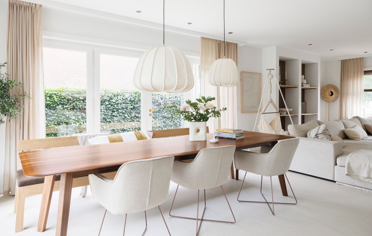 Gietvloer Arturo, muurverf Ral 9016, eettafel De Machinekamer, stoelen Jesper Home, eetkamerbank Pilat&amp;Pilat, hanglampen Ay Illuminate, vaas By-Boo, kandelaar Wick, gordijnen Karwei, babyhangmat Moonboon, wanddecoratie Hout van Toen, bank Room108. Overig onbekend. vtwonen 03-2024 | fotografie Margriet Hoekstra