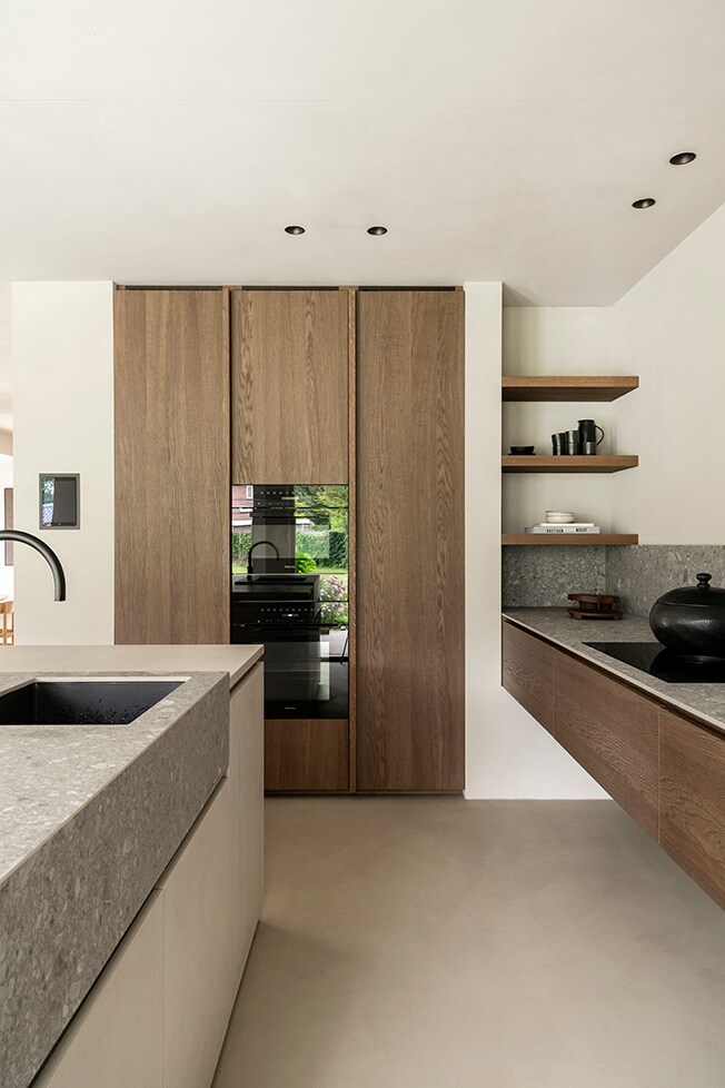 Het hout voor de keukenkasten is hetzelfde hout als voor de masterbedroom en en-suitebadkamerkasten is gebruikt. De achterwand is van Ceppo di Gre steen. De vloer heeft een microtopping afwerking. Fotografie Muk van Lil