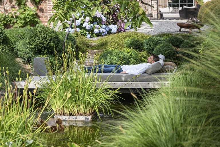 Een vijver in je tuin? Met een loungeterras er vlak naast geniet je er nóg meer van. Claude Smekens