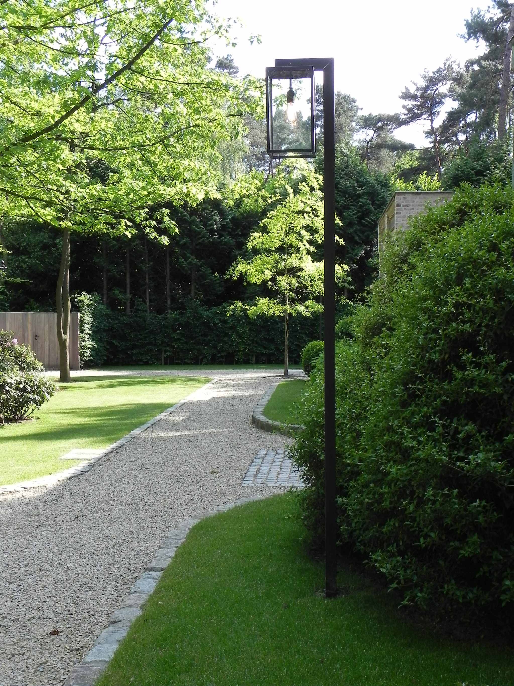 Geen enkel detail werd in dit tuinontwerp over het hoofd gezien. Blikvangers zijn onder meer de lantaarns die niet alleen ’s avonds maar ook overdag echte sfeermakers zijn. Nyche Lighting