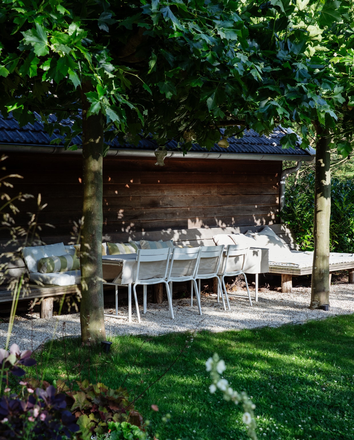 Een rij planten geeft schaduw bij de lange eettafel. Stoelen Fermob, tafel laten maken bij de lokale smid, doek van De Boerenbonthal als tafelkleed. vtwonen tuin 09 | styling Ilona Jongepier | fotografie Dana van Leeuwen