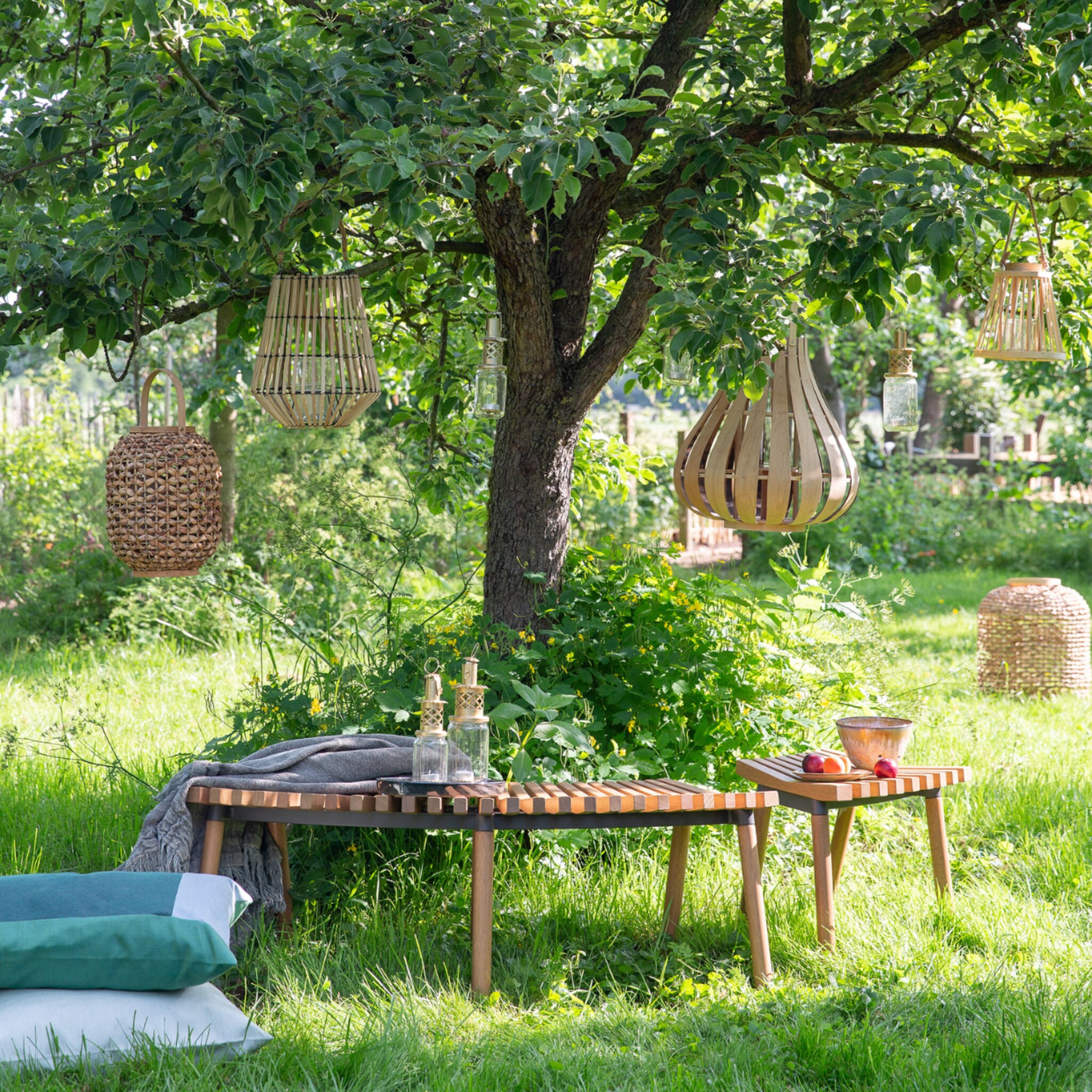 Tuin met bomen en lampionnen en tuinset