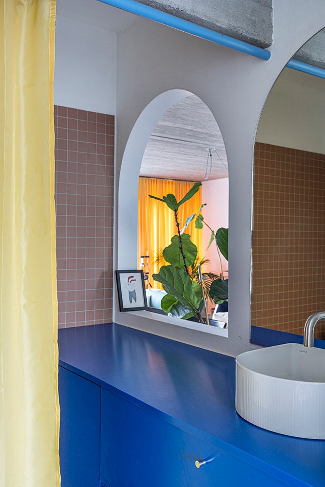 Badkamer met donkerblauw meubel in dakappartement van 50 m² Kaatje Verschoren