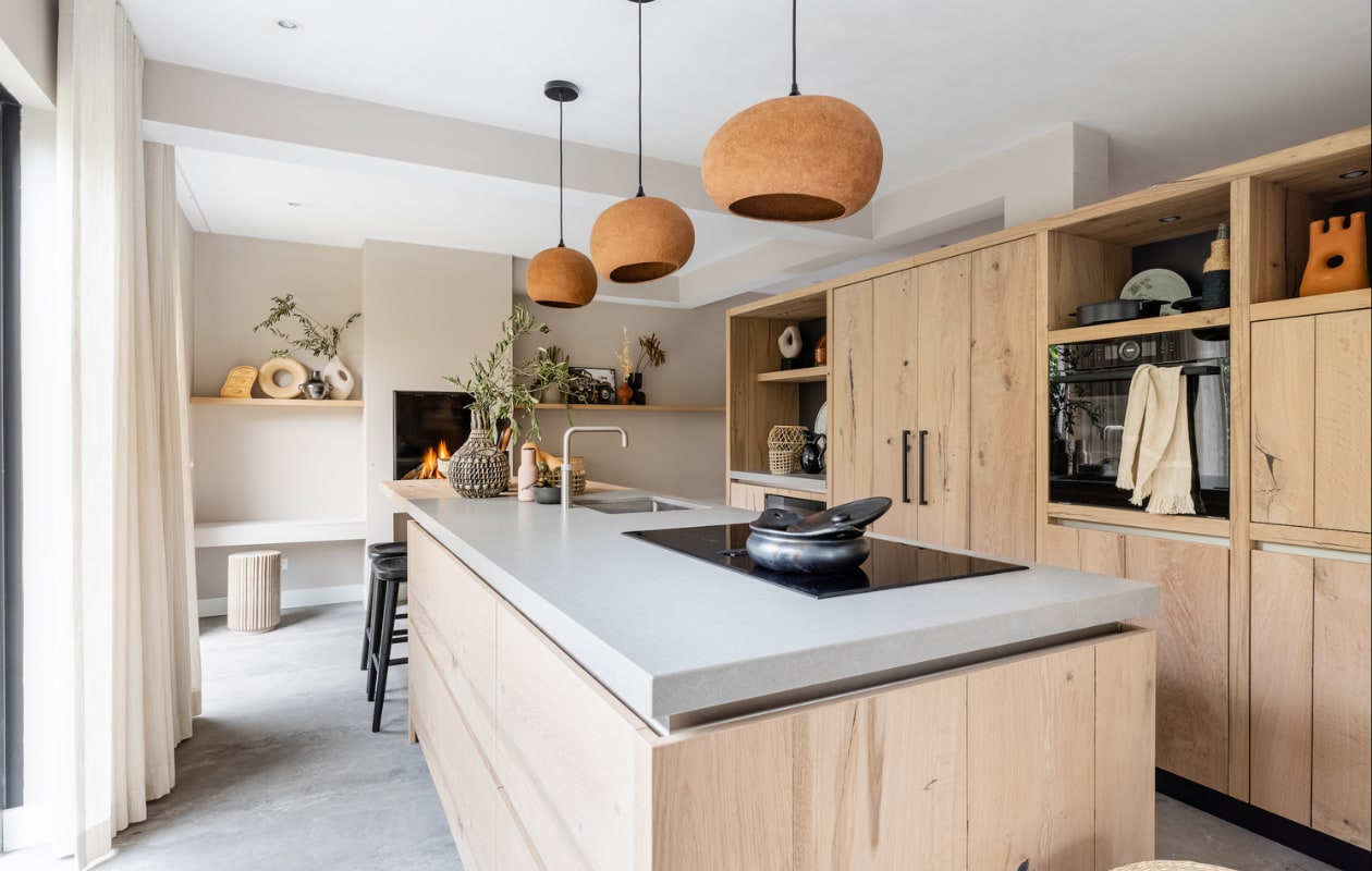 Keuken prijs op aanvraag (info@bminterieurmakers.nl). Stoomoven in Carbon Black van Bosch, prijs op aanvraag, inductiekookplaat met afzuiging van Bosch, prijs op aanvraag (bosch.nl). Lampen Pebble van gerecycled karton € 305,- (ayilluminate.com). Planten en droombloemen prijs op aanvraag (plantje.nl). Barstoelen Lucille van Eleonora, per stuk € 129,- (eijerkamp.nl). Handdoek van Bloomingville € 21,90 (vtwonen.nl). In keukenkast linksboven: siervorm € 29,99 (hm.com), onderzetter Groove € 39,- (eijerkamp.nl), borden, mokken en kommen Urban Nature Culture en Serax vanaf € 11,10, waterglas van Iittala € 21,85 (vtwonen.nl).  vtwonen weer verliefd op je huis seizoen 15, aflevering 7 | styling Liza Wassenaar | fotografie Sonja Velda