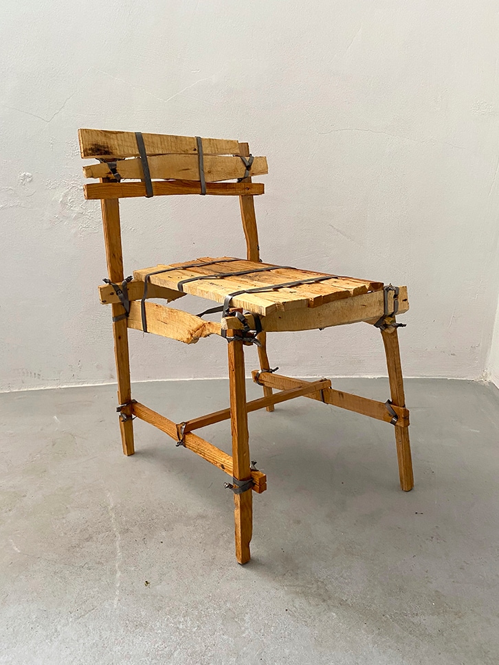 Een van de stoelen uit Teuns Teunland. Gemaakt uit gekliefd pallethout en aan elkaar gebonden met ijzeren strips. Teun Zwets