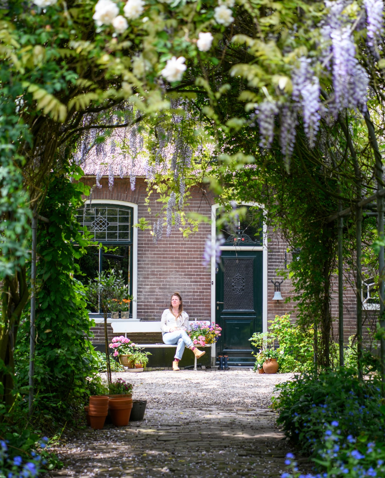 Bankje gekregen van vorige eigenaar, potten tuincentra en kringloop. Verf deur zat er al op. vtwonen binnenkijken special 131-2024 | productie Inside Homepage | styling Kim Timmerman | fotografie Louis Lemaire
