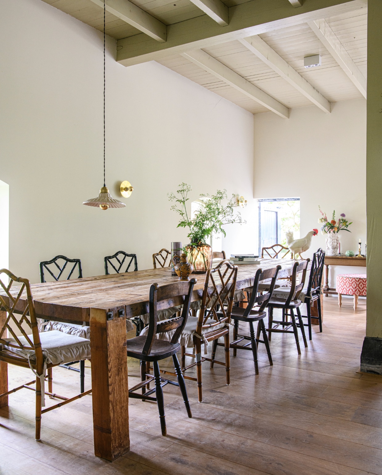 Eettafel zelfgemaakt van houten balken. Hanglamp Sissy-Boy Homeland. Wandlamp uit Madrid. Tijgervaas HKliving. Andere vaasjes kringloop. Stoelen erfstukken en Marktplaats. Antieke sidetable en poef erfstuk. Witte vaas Italiaanse markt. Overig onbekend. vtwonen binnenkijken special 131-2024 | productie Inside Homepage | styling Kim Timmerman | fotografie Louis Lemaire