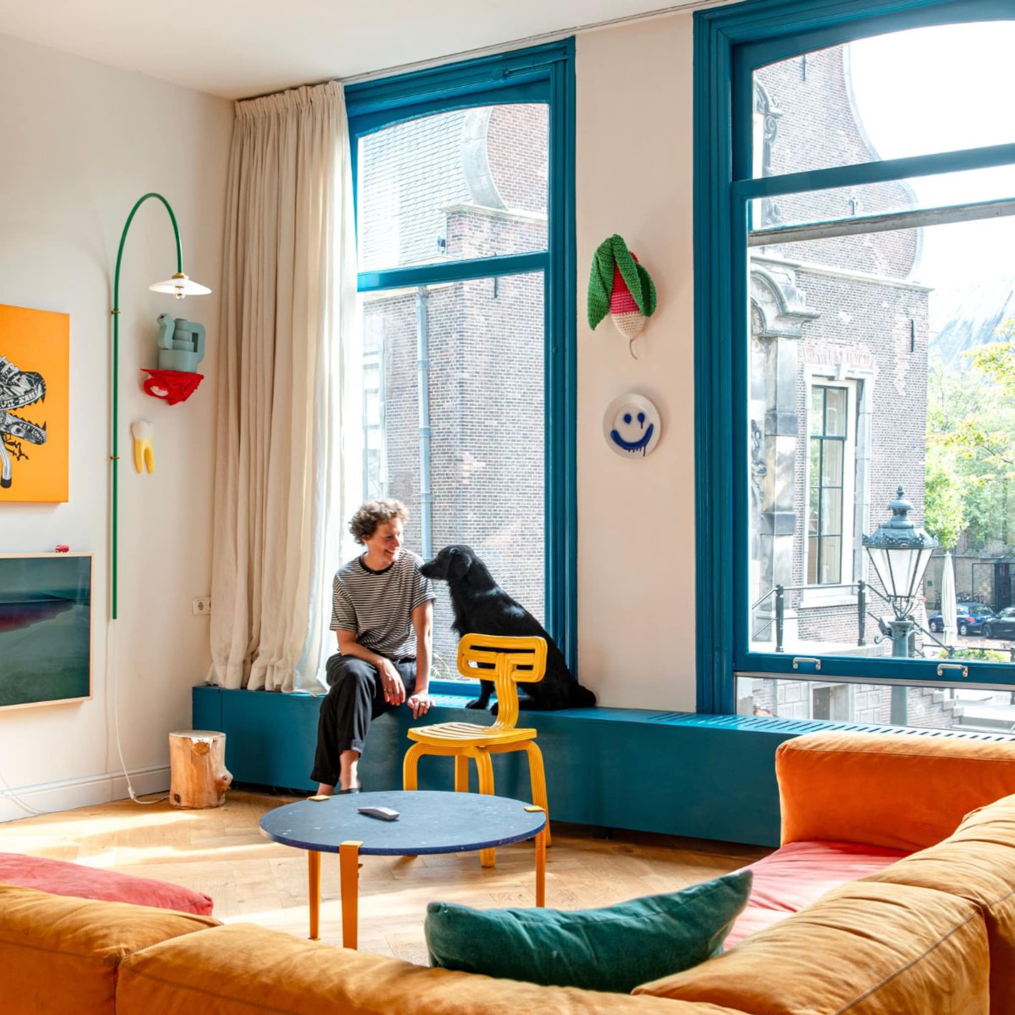 Woonkamer met grote raampartijen en blauwe kozijnen