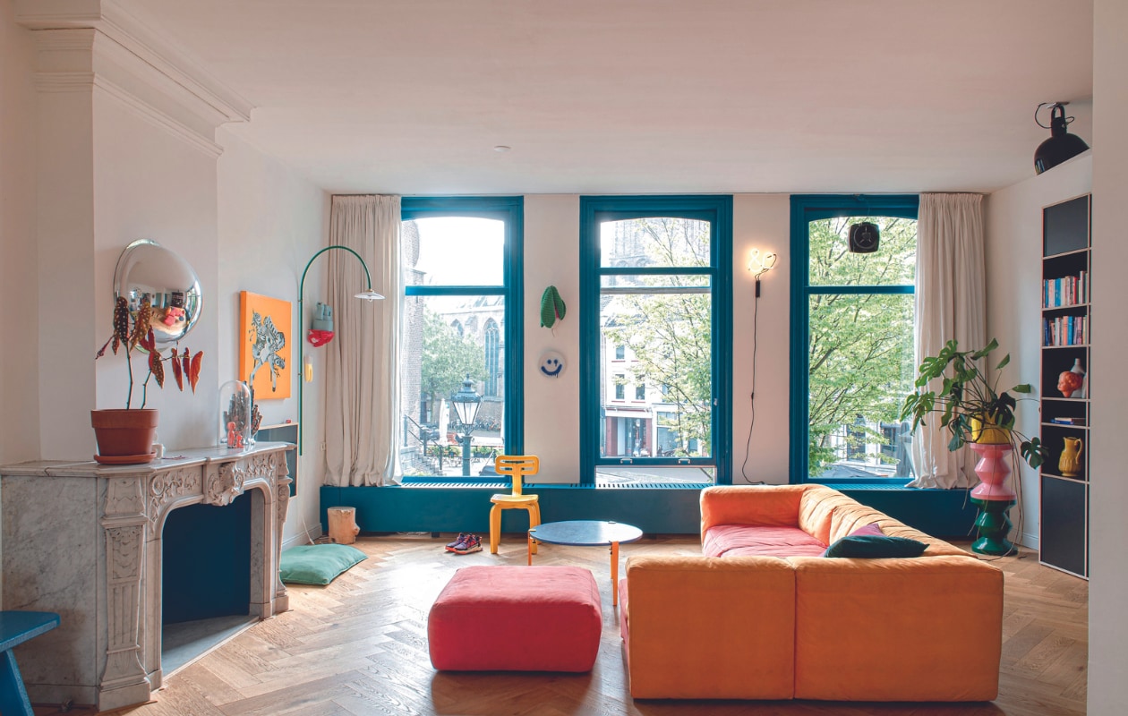 Bank Hay, salontafel Tiptoe, systeemkast Tylko, plafondlamp rommelmarkt, opgestapelde krukken Polspotten, plantenpot erop Serax, gele stoel Dirk van der Kooij, gehaakte radijs Anne-Claire Petit. Smileybord en bolspiegel The Dirt. Booglamp Muller Van Severen, oranje kunstwerk Boxie, rode wandplank studio Thier &amp; van Daalen, pot van Hanna Kooistra, verf kozijnen Piet Hein Eek Project Blue 03 van Lacq. Overig onbekend. vtwonen 04-2024 | productie de Binnenkijkers | styling Jeske Weel | fotografie Caroline Coehorst