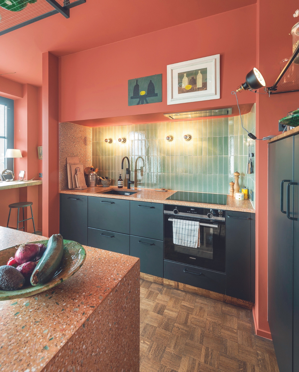 Keuken en klemlamp Ikea. Aanrecht Best Decor, tegels The Winchester Tile Company, vergelijkbare kraan Sanitairwinkel, wandlampen Artemide, krukken Hay, hangrek op maat gemaakt, verf Red Earth van Farrow &amp; Ball. Overig onbekend. vtwonen 04-2024 | fotografie Mr. Frank