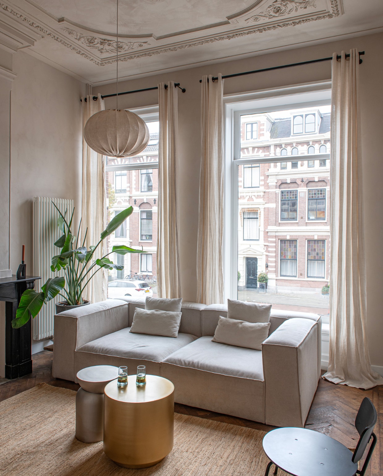 In de tv-kamer bank Wehkamp. Goudkleurige bijzettafel House Doctor, kandelaar en vloerkleed via JAS. Glazen meegenomen uit Marokko, stoel en hanglamp H&amp;M Home. Overig onbekend. vtwonen binnenkijken special 131-2024 | productie De Binnenkijkers | styling Jeske Weel | fotografie Caroline Coehorst