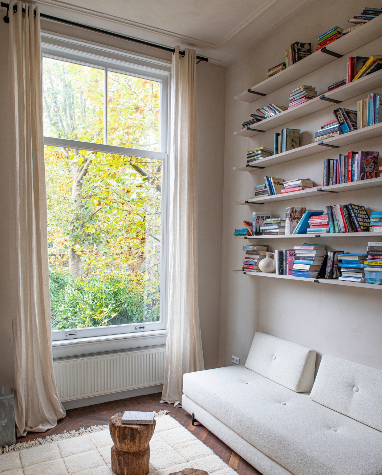 Logeerbank onbekend, krukjes en vloerkleed uit Marokko, boekenplanken gemaakt door Siep Keuken &amp; Interieur. vtwonen binnenkijken special 131-2024 | productie De Binnenkijkers | styling Jeske Weel | fotografie Caroline Coehorst
