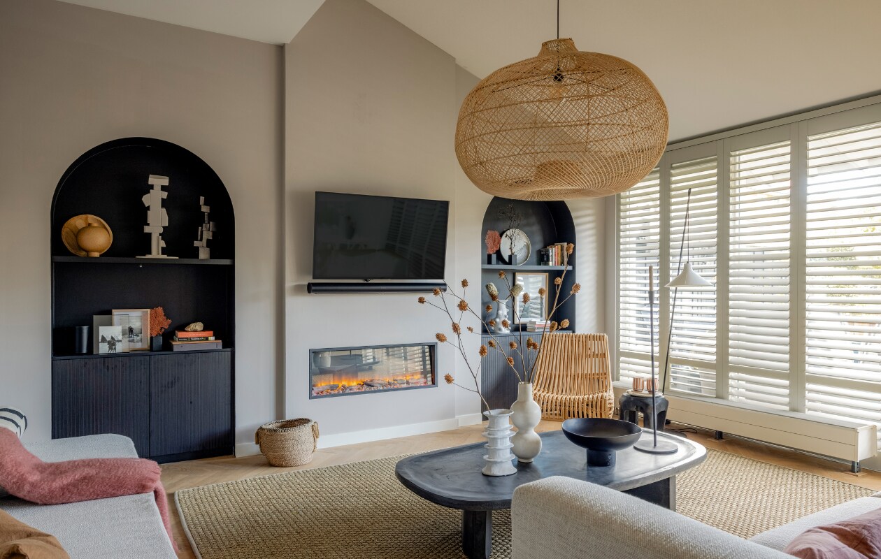 Zithoek -  Muurverf en lak zithoek Urban Taupe en lak boogkasten Late Night Black van Flexa Creations (flexa.nl). Shutters Cream Grey (jasnoshutters.nl). Inbouwbank, niskasten en boekenplanken gemaakt door Meijer Maat Interieurs (meijermaatinterieurs.nl). Wandkunstwerk van resthout en boogkasten gemaakt door Michiel Draaisma (md-sign.nl). Bank Kuvio, fauteuil Cinque Terre, kruk Root, stof voor matraskussens Vesper 322 Crystal, kussen Kelim, schaal Relevé Platter, kandelaar Hoy Casted (eijerkamp.nl). Handgemaakte salontafel Fille (boxworx.nl). Vloerkleed Quattro (cunera.nl). Hanglamp Rotan Apple (manggisliving.nl). Schuim voor kussens en matraskussens (abc-schuimplasticshop.nl). Rolkussens gemaakt met stof 10779/23 RIF van Nobilis (wva.nl). Kussens Cinnamon en Terra, plaid Mohair in terra (bymolle.com). Vaas Billy en vloerlamp Seam van Serax (vtwonen.nl/shop). Tafellamp Escape, object Aosta, vaas Vico, schaal Orion (urbannatureculture.com). Vaas Tadelakt, mokken Mug L, houten lepel Harira (householdhardware.nl). Kussen Terracotta (tica.nl). Takken (plantje.nl). Zwarte geluidsinstallatie van Sonos (ep.nl). Waaiers klein en middelgroot (violierathome.nl). Fotolijst (zarahome.com). Fotolijsten (action.com). Print (drukkerij-flora.nl). Steen en boeken kringloop. Overig privébezit. Beeld Weer verliefd op je huis aflevering 10 seizoen 19 | styling Liza Wassenaar | fotografie Sonja Velda