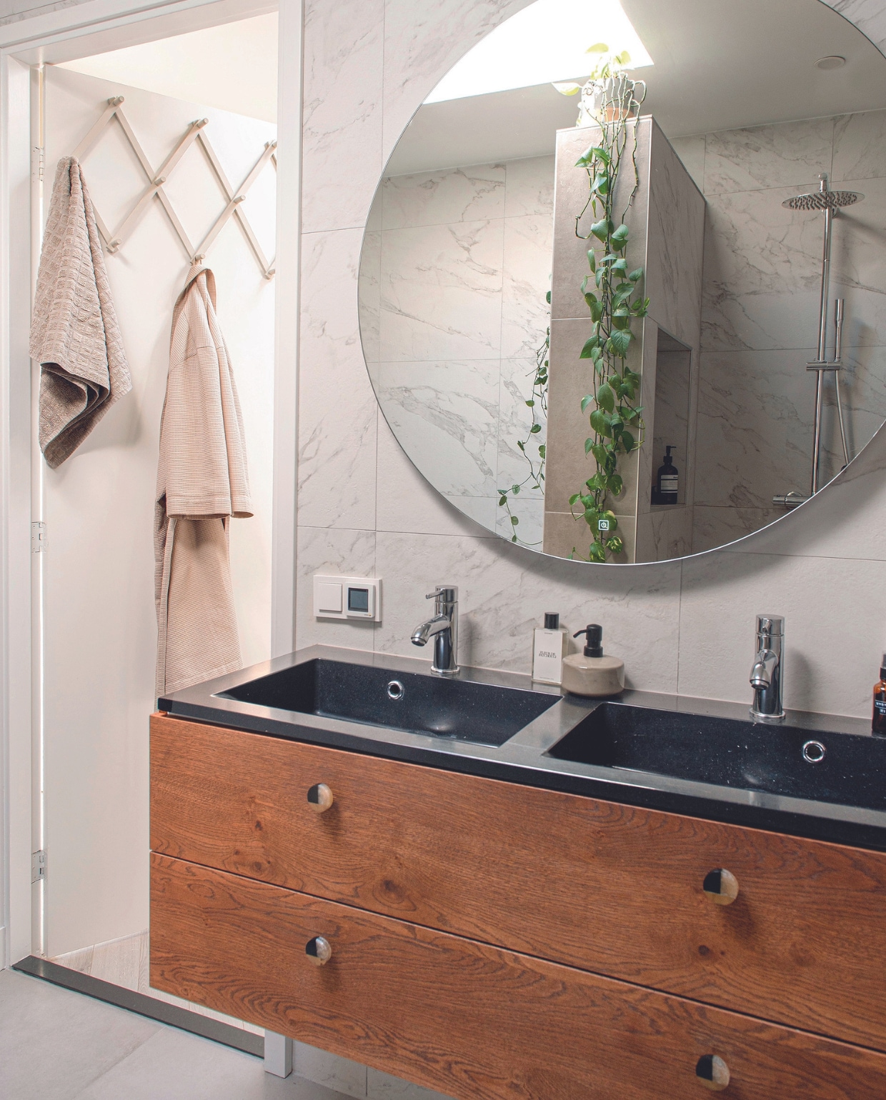 Kapstok Søstrene Grene, geverfd in Chase van D’Imago New Traditionals. Badjas H&amp;M, badkamermeubel Meubelatelier Sand-Ambacht, meubelknoppen Zara Home, zeepdispenser Jysk. Overig onbekend. vtwonen 04-2024 | productie De Binnenkijkers | fotografie Caroline Coehorst | styling Jeske Weel