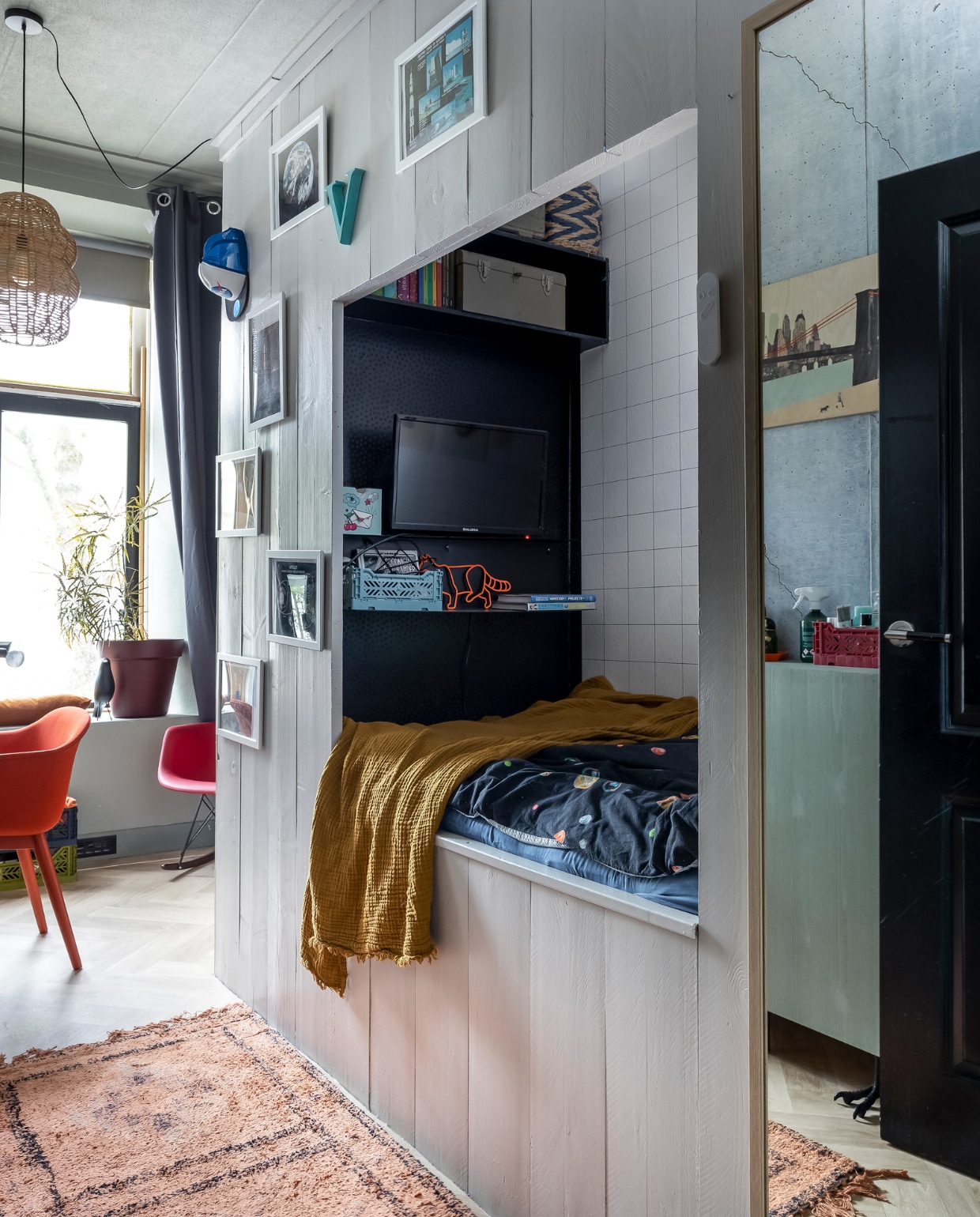 Bed zelfgemaakt, beddengoed Snurk, plaid en groene kast Ikea. Lamp en vloerkleed BMK Interieurs. Houten poster New York van Storywood, Nasa-pet H&amp;M, kratjes Hay. Stoelen Muuto en Vitra, tegelbehang Kwantum. Verf bedstee Elephant Breath, verf kast Card Room Green van Farrow &amp; Ball. Lamp BMK Interieurs, gordijnen Ikea. vtwonen binnenkijken special 131-2024 | fotografie Henny van Belkom