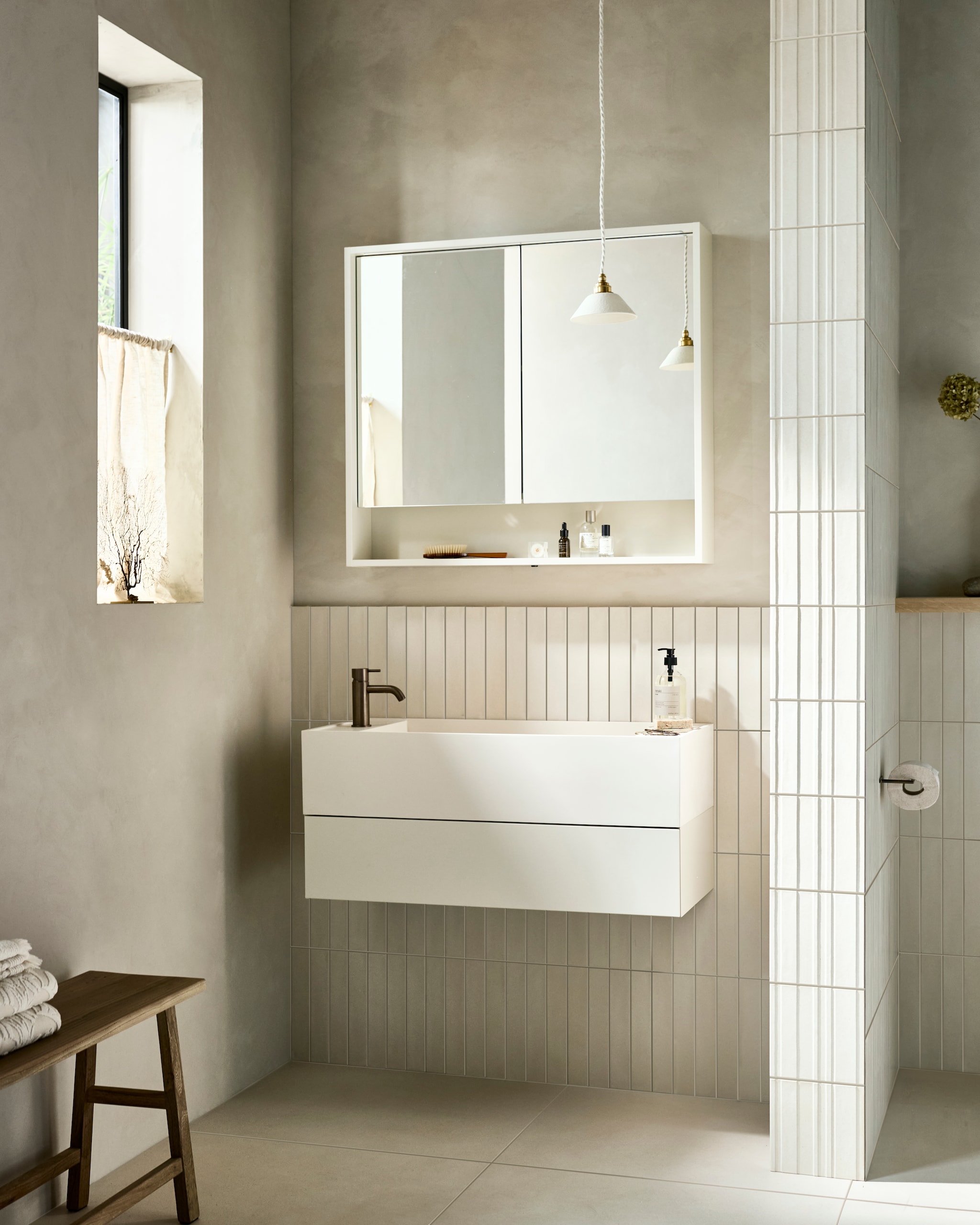 Kunststof halfhoge kolomkast Bend in matzand, met push-to-opensysteem, 40x35,5x102 cm (bxdxh) € 1273,-. Top solid bad Soft Edge in matzand, 160x73x59,5 cm (lxbxh), 200 liter € 4970,-. Vloer: vloer- en wandtegel Earth Argilla, 60x60 cm, per m² € 64,50. Achterwand: wandtegel Earth Argilla, 5x30 cm, per m² € 79,50. M.m.v. vtwonen.nl/shop (haak van Ferm Living), merakimoments.com (dienblad, mok, borstel, bruine fles), zarahome.com (houten kwasten, geurkaars, zwart dienblad, bruine pot met deksel, zwarte opbergkistjes), sissy-boy.com (kom), thefinestore.com (handdoeken Karin van Autumn Sonata, houten dienblad Filipine), pietjonker.nl (kruk, wandlamp), entertheloft.com (kandelaar Duca van Audo Copenhagen), aesop.com (mondwater), vestingh.nl (kalkverf Dark Taupe van Lab Paint). Overig privébezit. vtwonen 06-2024 | fotografie Sjoerd Eickmans | styling Kim van Rossenberg