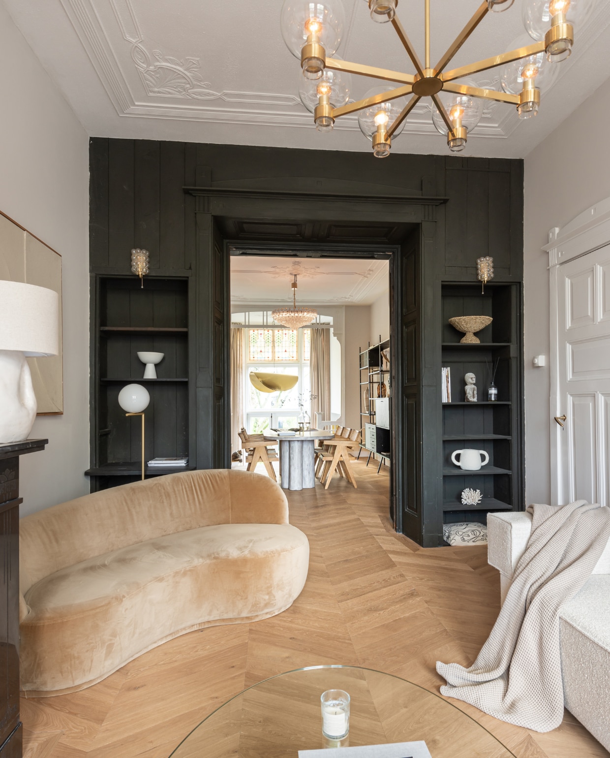 Bank Flow Rotterdam, kussens H&M home. Ecru kunstwerk in midden van Edith Beurskens voor The Poster Club, rond sculptuur Huis vol Stijl, posters Desenio. Vintage salontafel en plafondlamp van Hans-Agne Jakobsson, vintage wandlamp van Helena Tynell. Plaid Made, accessoires in kast Maison Jolie, vintage en souvenirs. Overig onbekend. vtwonen 11-2022 | Productie Living Inside | Fotografie Peter Dekens | Tekst Marzia Nicolini | Tekstbewerking Anne-Flore Muller