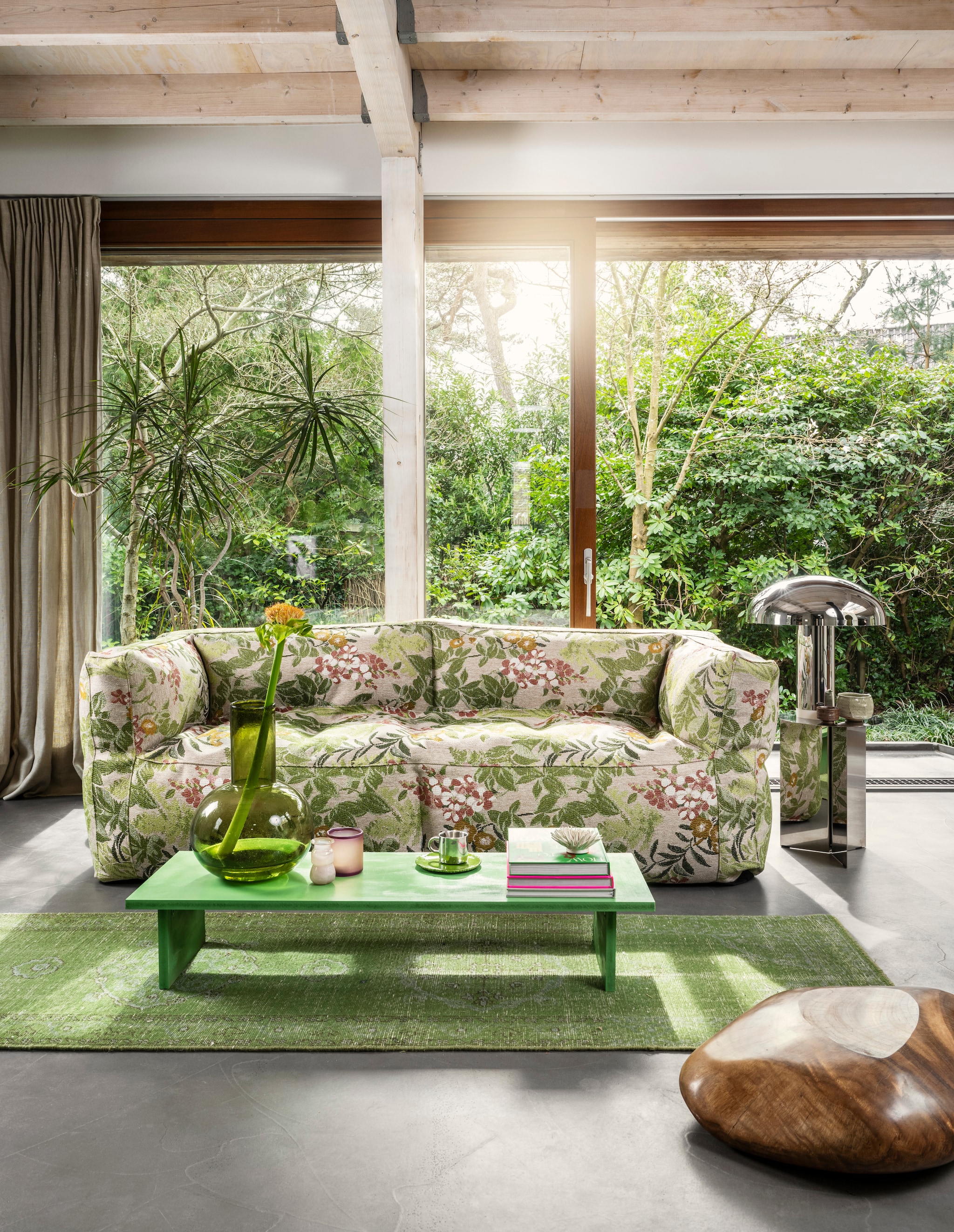 Driezitsbank Flowers, indoor/outdoorstof, 223x80x75 cm (bxdxh) € 2400,- (bryck.nl). Acrylglazen tafellamp Lounge van HKliving € 395,- (vtwonen.nl/shop). Wollen loper Knotted, 80x350 cm € 795,-, glazen vaas Glass Blown € 129,-, paars glazen waxinelichthouder Tea Light Holder € 19,95, roze koffietafelboek Limited Edition Lookbook € 39,95 (hkliving.com). Groen koffietafelboek How to live with objects € 42,04 (bol.com). Keramieken bord van Stichting Zodiezijn, set van 4 € 24,95 (mooidoormij.nl). Stalen bijzettafel Slit, 35x46 cm (Øxh) € 519,- (hay.nl). Rvs mok € 2,50, glazen vaasje € 4,- (hetgoed.nl). Salontafel zelfgemaakt. Overig privébezit. vtwonen 06-2024 | styling Kelly van Gendt | fotografie Stan Koolen