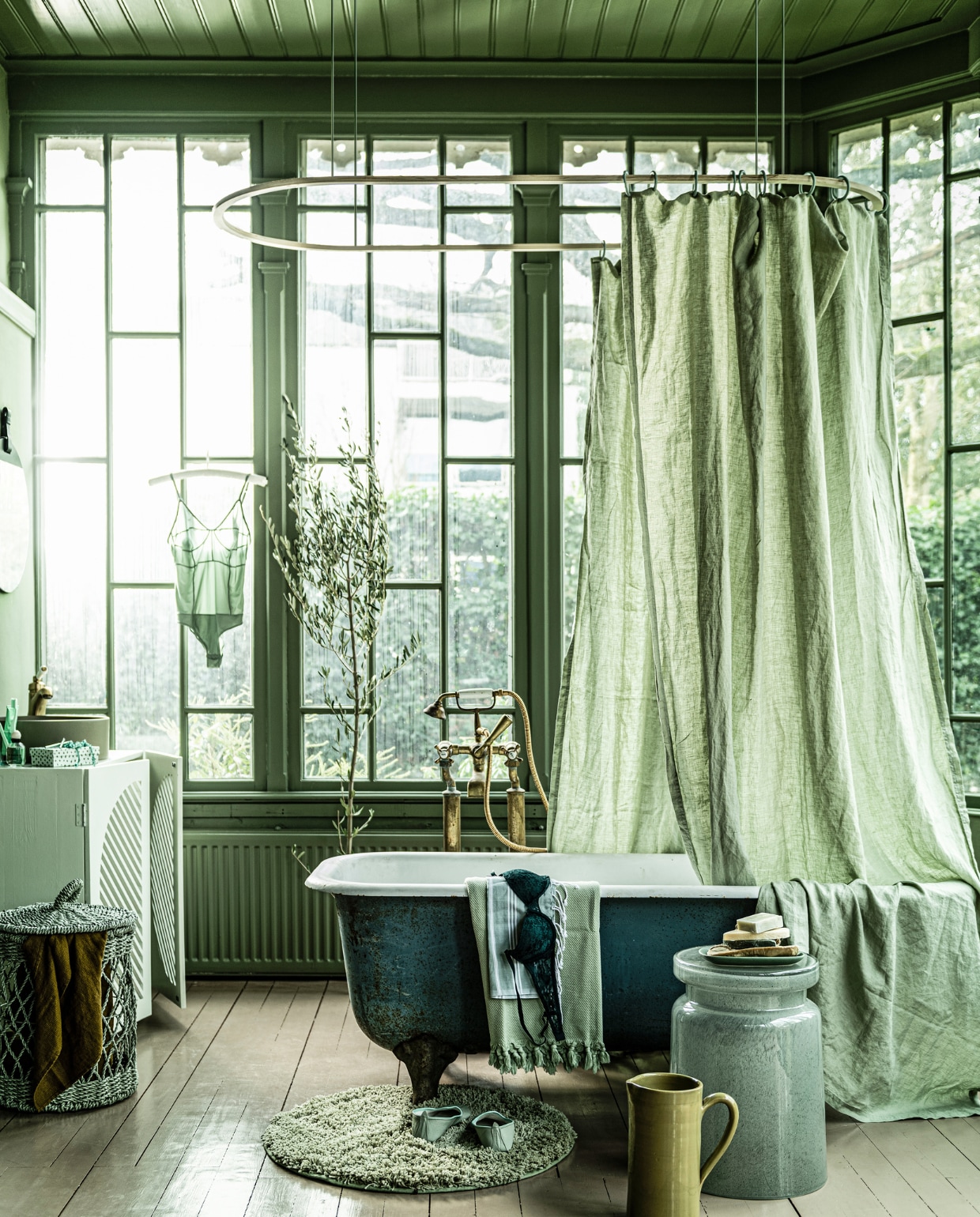 Wastafelmeubel prijs op aanvraag (com-anders.nl). Legergroene wasbak mat, 40x12 cm € 489,- (tegeldepot.nl). Oud bad op poten € 750,-, badkraan € 700,-, wastafelkraan € 250,- (oudebouwmaterialen.nl). Glazen kruk € 1115,- (badenbaden.nl). Kan, bord, bovenste zeep prijs op aanvraag, onderste zeep € 8,50, wasmand € 34,50, tandenborstel van Hay € 4,- (loods5.nl). Linnen doek Swaddle moutarde € 25,- (archive-store.nl). Body van Lovestories € 80,-, glazen vaasje € 9,95 (maisonnl.com). Kartonnen stippendoosje vanaf € 0,78, ringen douchegordijn prijs op aanvraag (sostrenegrene.com). Rek douchegordijn van hout € 52,- (zandvlietlisse.nl). Kralenketting € 39,90, hamamdoek klein € 8,95, groot € 29,95, flatjes € 22,95 (ottomania.nl). Make-up kwasten, set van 5 € 6,95 (bol.com). Ronde badmat € 24,99, geurtje € 14,99, beha € 12,99, linnen stof als douchegordijn € 39,99, handcrème € 7,99 (hm.com). Middelste zeepjes per stuk € 5,95 (mijnstijl.com). Rek boven bad privébezit. vtwonen 04-2020 | styling Liza Wassenaar | fotografie Sjoerd Eickmans