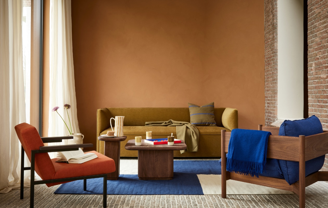 Muurverf kalkverf nr. 84, per liter € 25,- (dullerenco.nl). Bank 7840 Pillow van Lex Pott, 213x72x76 cm (bxdxh) € 3225,- (gelderlandgroep.com). Fauteuil rode zitting SZ 63 van Martin Visser, 69x78x72 cm € 1891,- (spectrumdesign.nl). Walnoothouten fauteuil blauwe zitting Arbour Club, 75x85x75 cm (bxdxh) € 2909,-, vloerkleed Flat Works van Ethan Cook, katoen en wol, vanaf € 559,-, backgammon spel € 55,-, oker wollen plaid Mono Blanket, 130x180 cm € 115,- (hay.nl). Gestreept kussen Grand van Ferm Living, katoen en linnen € 59,- (vtwonen.nl/shop). Mangohouten salontafel Toke van Nordal € 865,-, mangohouten bijzettafel Toke van Nordal € 379,- (deens.nl). Blauw wollen kleed € 99,95 (aabe.nl). Okergele keramieken mokken Locoto van Nordal € 13,95 (mdliving.nl). Gestreepte keramieken schenkkan € 69,- (nordal.eu). Keramieken pot met oren Odin € 27,50 (iblaursen.dk). Overig privébezit. vtwonen 08-2023 | styling Marianne Luning | fotografie Alexander van Berge