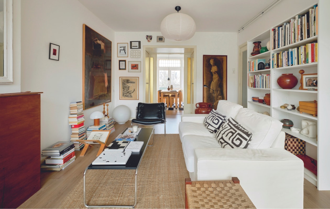 Koffietafel van Marcel Breuer, fauteuil Osaka van Martin Visser. Kussens Vilmie Figur, boekenkast, vloerkleed en bank Kivik van Ikea. Dressoir, kruk en bollamp op de vloer vintage. Rijstpapieren hanglamp Hay. Aardewerk uit Spanje, Italië en kringloopwinkels. Kunstwerken gekregen van familie en vrienden. Overig onbekend. vtwonen 05-2024 | fotografie Mr. Frank