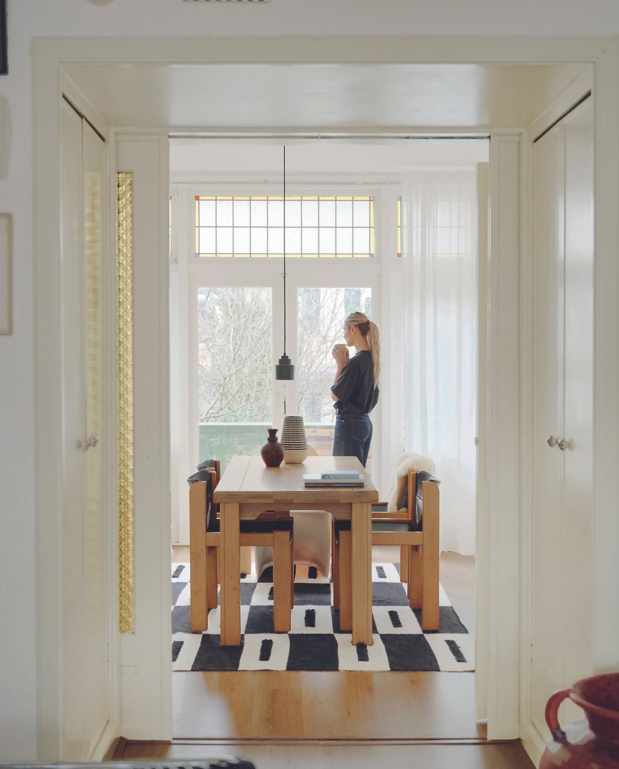 Eettafel vintage, tuigleren stoelen Ibisco, vloerkleed Fést, boekenkast Ikea, hanglamp Zuiver. Aardewerk uit Spanje, Italië en kringloop-winkels. Kunstwerken gekregen. Overig onbekend. vtwonen 05-2024 | fotografie Mr. Frank