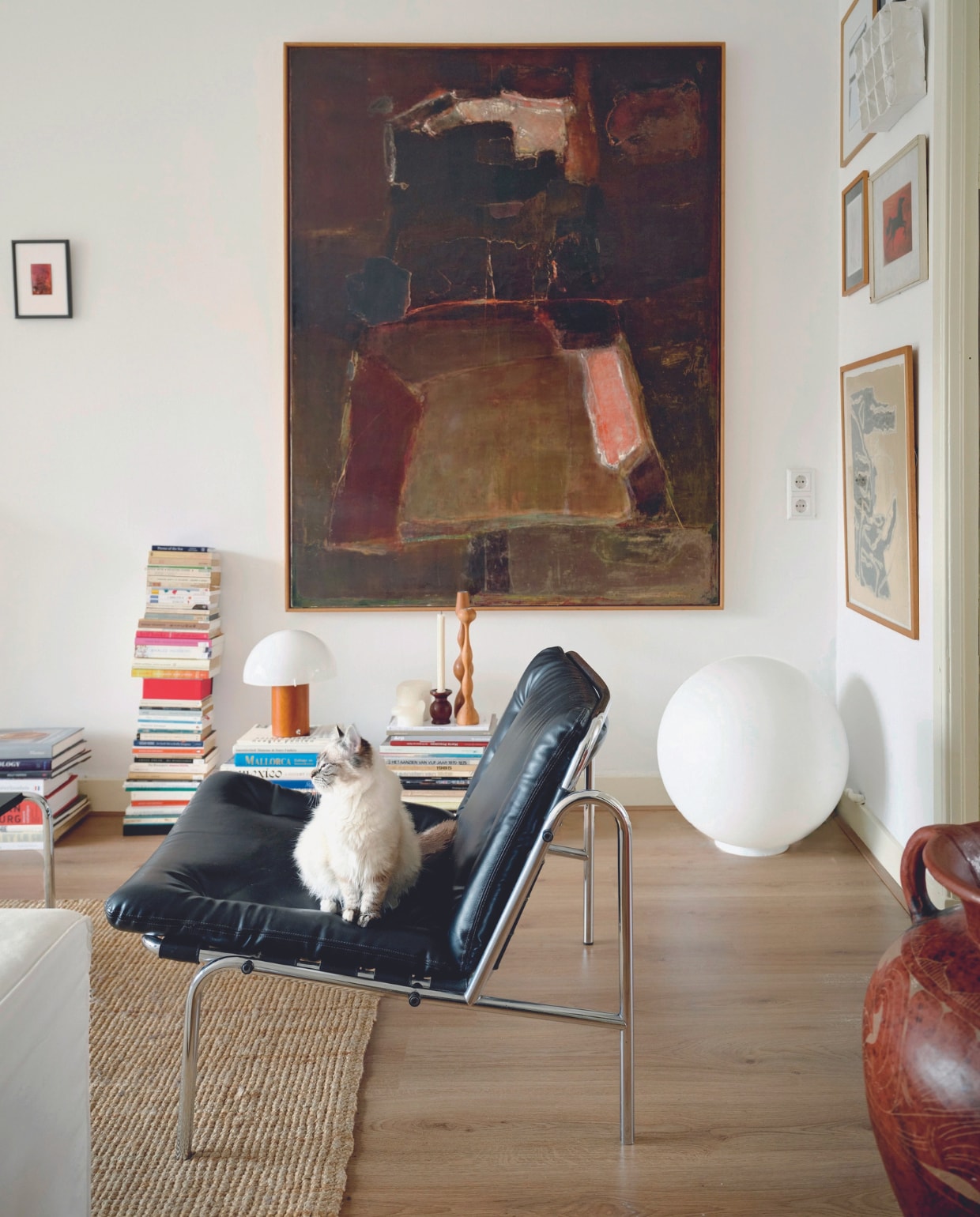 Fauteuil Osaka van Martin Visser. Bollamp en kandelaars vintage. Vloerkleed Ikea, kunstwerken gekregen van familie en vrienden. Overig onbekend. vtwonen 05-2024 | fotografie Mr. Frank