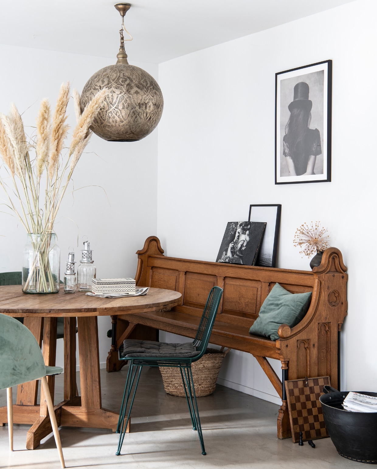 Kerkbank Marktplaats. Ronde tafel Hkliving. Groen kussen H&amp;M Home. Groene fluwelen stoelen Søstrene Grene. Groene metaaldraad stoel tweedehands. Vaas Loods 5. Glazen lantaarns op tafel en zwarte rubberen mand naast bank Household Hardware. Kistje Zara Home. Hanglamp Zenza. Kunstwerk aan muur ingelijste foto van Desinio, foto’s op de bank privéfoto’s vtwonen 09-2020 | productie Insidehomepage | fotografie Louis Lemaire | styling Marit Saladini