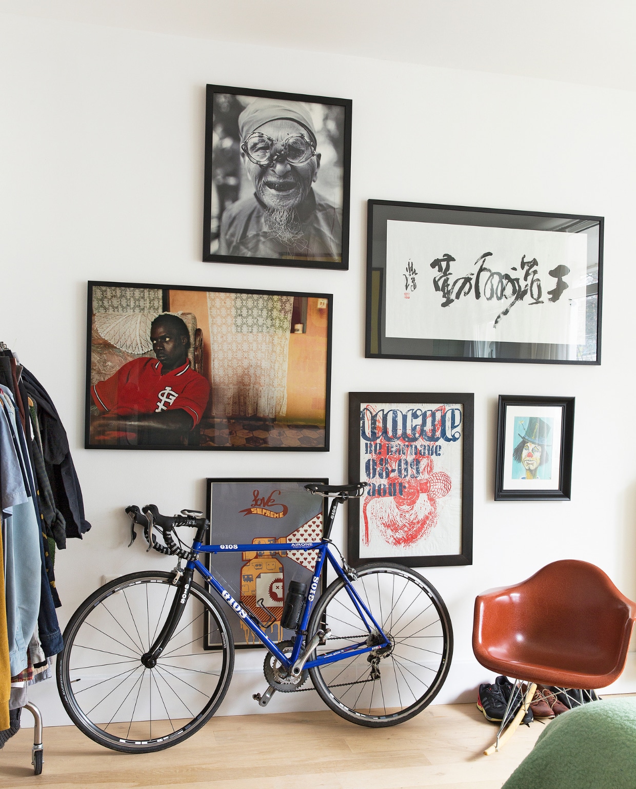Foto van de ouderslaapkamer. Racefiets van Gios, stoel Eames Rocker van Vitra.Veel kunstwerken aan de muur zijn afkomstig van vakantiereizen. vtwonen binnenkijken special 121-2017 | styling Emmy van Dantzig | fotografie Jansje Klazinga