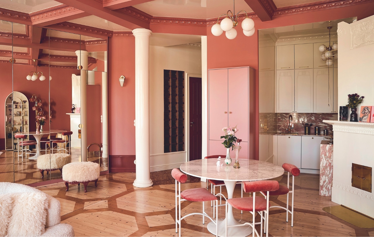 Marmeren eettafel uit Engeland. Stoelen Tokyo van Rodney Kinsman, zelf geverfd en bekleed. Plafondlampen tweedehands, kasten gemaakt door Aina-Keittiöt. Werkblad en achterwand van Rosso Norwegian-marmer van Tulikivi. Items op werkblad vlooienmarkt, betegelde haard wit geverfd. Vloerplanken origineel, patroon geverfd door Meja. Overig onbekend.