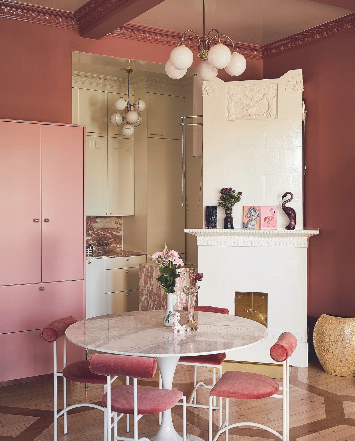 Marmeren tafel uit Engeland. Stoelen Tokyo van Rodney Kinsman, zelf geverfd en bekleed. Plafondlampen tweedehands, kasten gemaakt door Aina-Keittiöt. Werkblad en achterwand gemaakt van Rosso Norwegian-marmer van Tulikivi. Vloerplanken origineel, patroon geschilderd door Meja. Betegelde haard wit geverfd, paneelplafond zelfgemaakt, sierlijsten D-Cor. Overig onbekend. vtwonen 05-2024 | productie Living Inside | fotografie Krista Keltanen