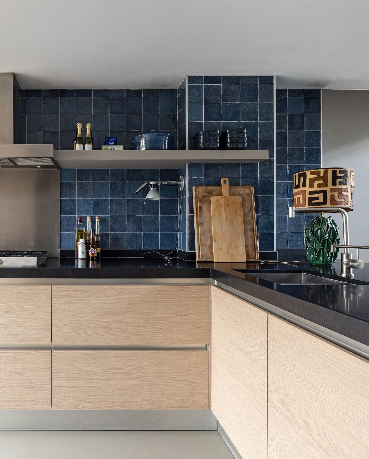 vtwonen tegels Craft Midnight Blue Glossy Decor, Douglas &amp; Jones. Wand naast oven in kleur Urban Taupe, Flexa. Keuken gewrapt in W144, Stickermaster. Rolgordijn op maat, Karwei. Zilveren vacuümblender, Bosch.Oven met magnetron en app van Home Connect Bosch. Lamp op aanrecht: kap Afrikaanse stof op vaas, MadameGarage. Overig: privébezit. vtwonen weer verliefd op je huis seizoen 15, aflevering 9 | styling Fietje Bruijn | fotografie Sonja Velda