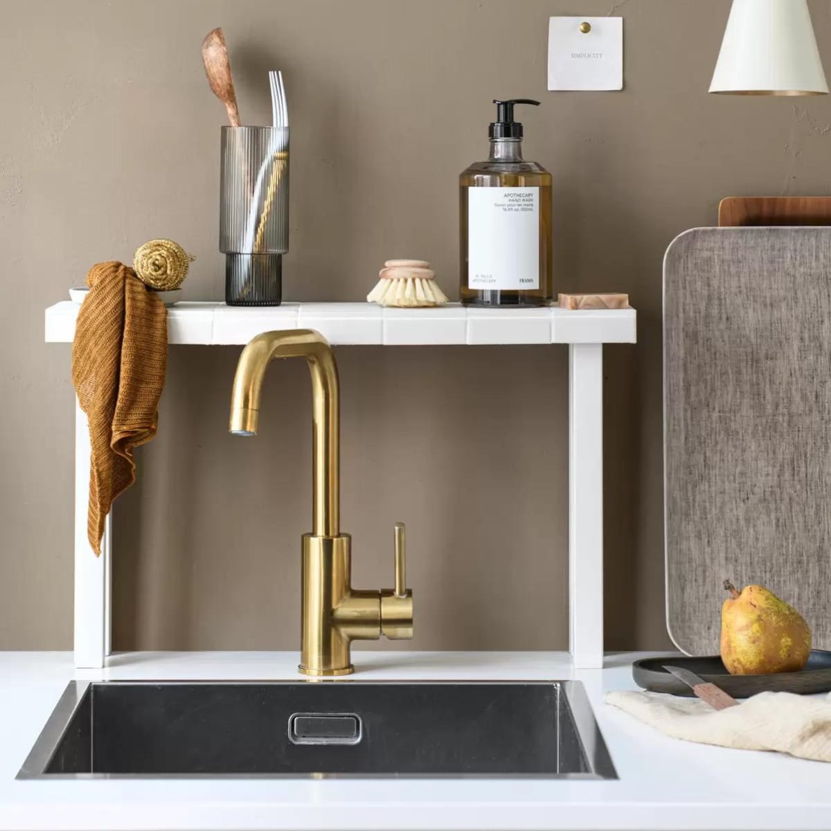 Muurverf 85% Dadel, 2,5 liter € 55,49 (flexa.nl). Longdrinkglas Ripple van Ferm Living in Smoked Grey, set van 4 € 59,-, handzeep in dispenser Apothecary van Frama, 500 ml € 45,-, houten dienblad Walnut Tray van Kinto € 47,-, dienblad Linen Tray Natural van Fog Linen Work € 34,-, linnen theedoek Pinstripe Honey van By Mölle € 15,-, houten schaal Filipine Tray Smoked Oak van Oslo Aula € 49,- (thefinestore.com). Metalen hanglamp Body van BePureHome € 49,95 (basiclabel.nl). Staalspons € 8,-, zeepblok van Helemaal Shea € 7,95 vtwonen 05-2024 DIY | styling Myla Griese | fotografie Louis Lemaire