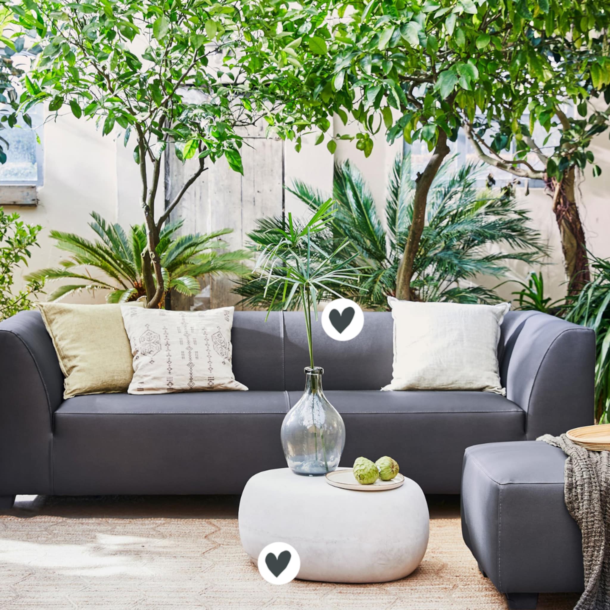 Tuin met grijze bank en witte bijzettafel