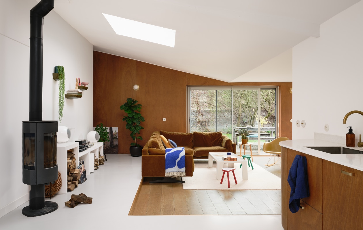 Bank AM.PM, schommelstoel Charles &amp; Ray Eames, witte vintage salontafel C&amp;B Italia. Houten bijzettafel, wandplanken en wandpanelen zelfgemaakt door Mathieu. Oranje kussen H&amp;M Home. Wandmeubel en wandplanken Ronan &amp; Erwan Bouroullec. Kunstwerk in de nis Marion WaïWaï, speakers Elipson. Overig onbekend. vtwonen binnenkijken special 131-2024 | productie Living Inside | fotografie Mr. Frank